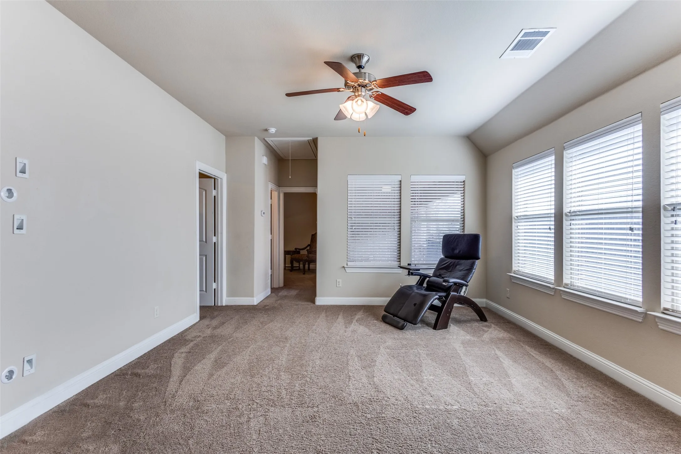 2nd floor game room with wall of windows and ceiling fan