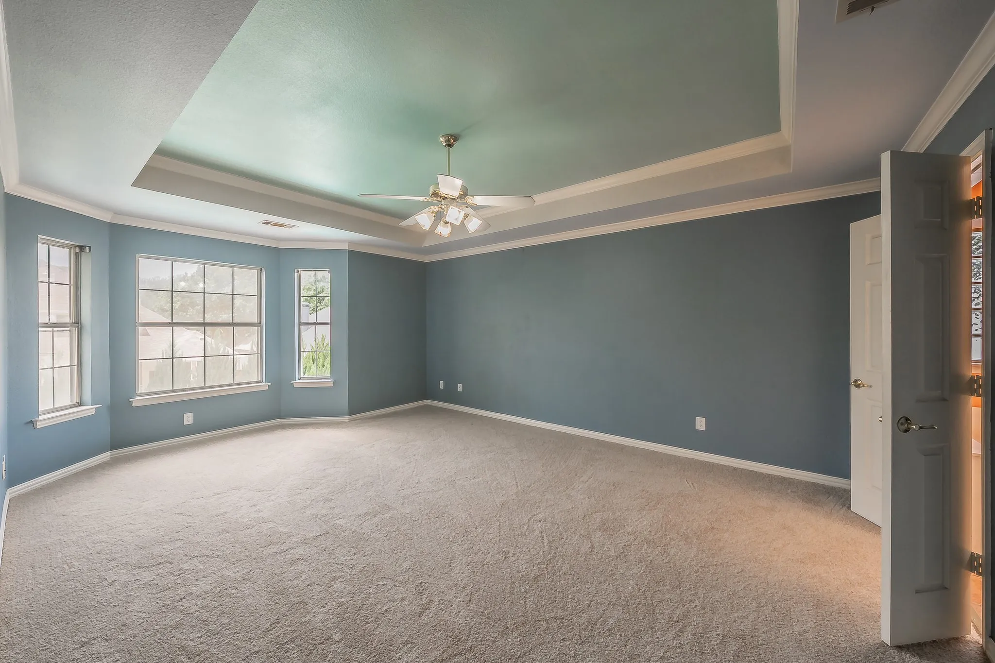 Primary suite overlooks the backyard and pool.