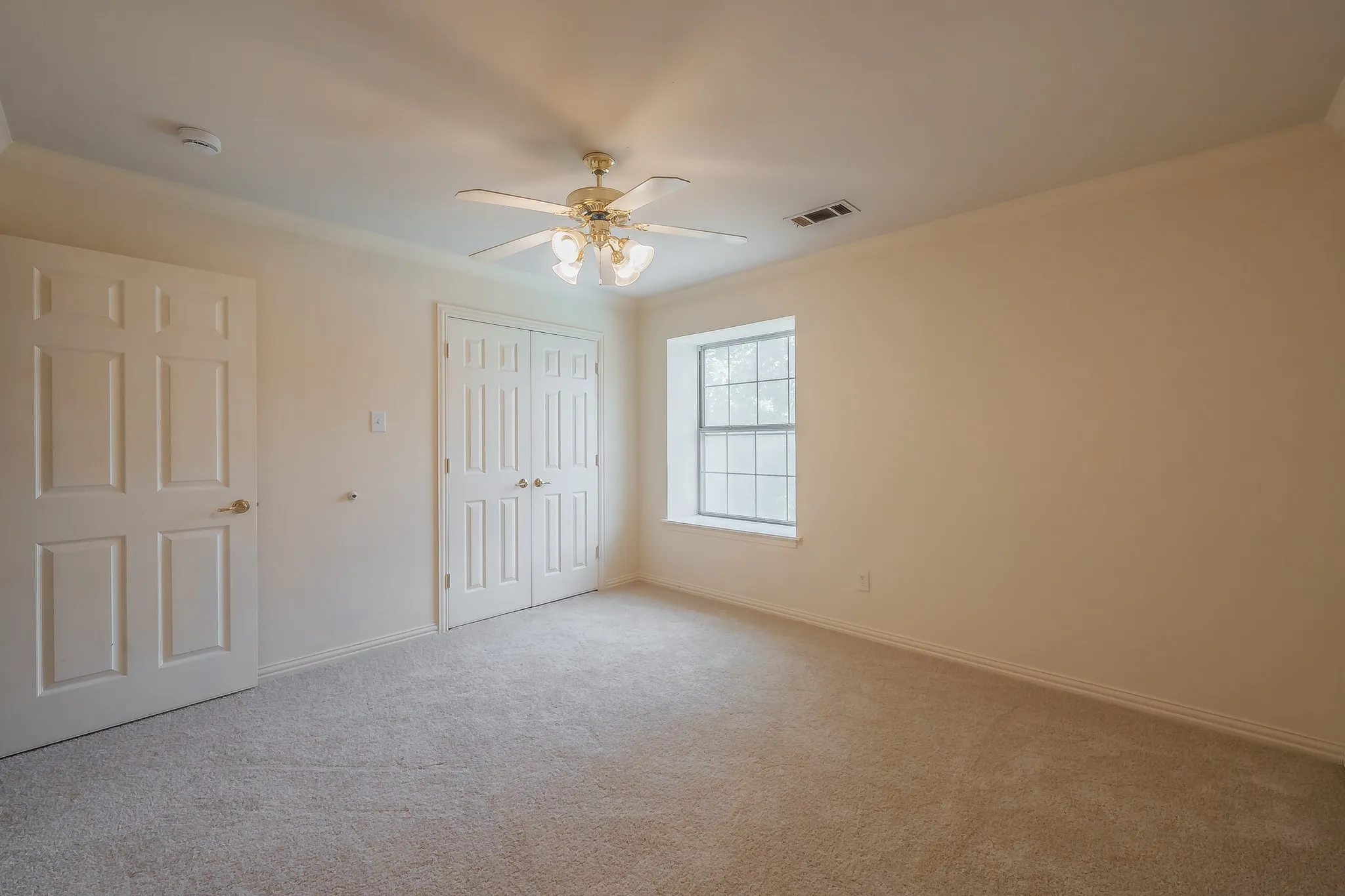Secondary bedroom with newly installed carpet and fresh paint.