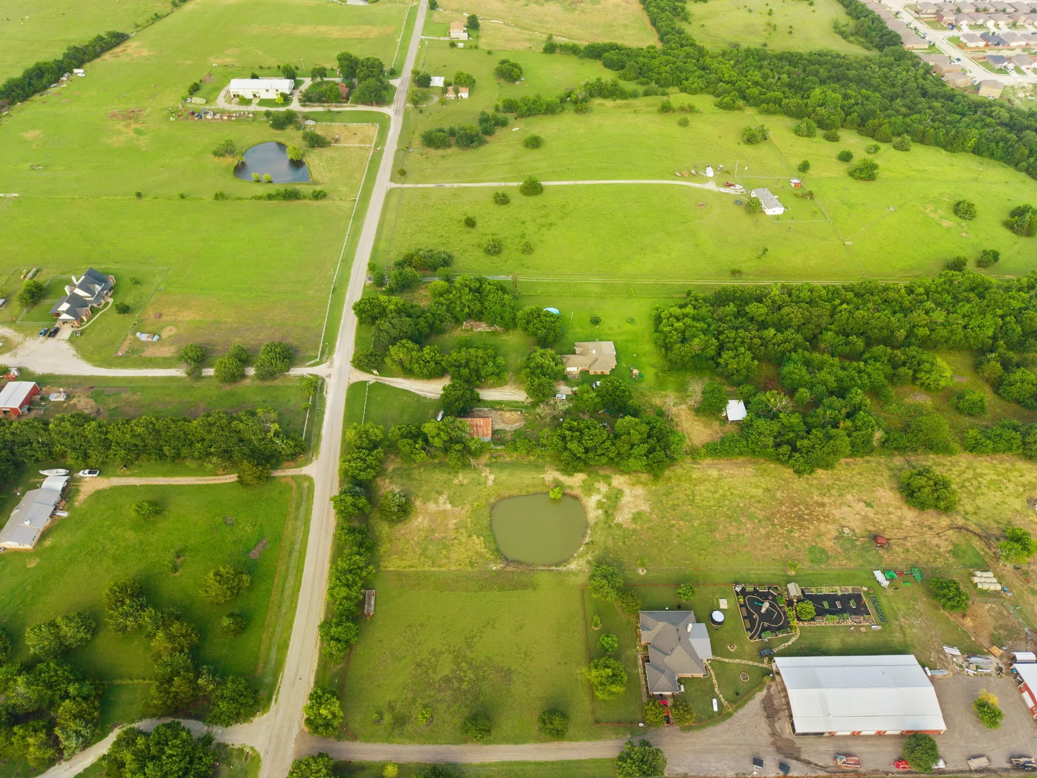 Expansive green spaces featuring multiple ponds and scattered mature trees
