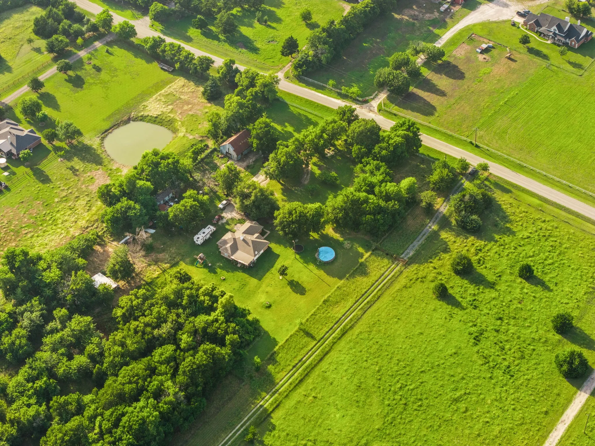 Expansive rural property featuring a primary residence, a private pond, and ample green space