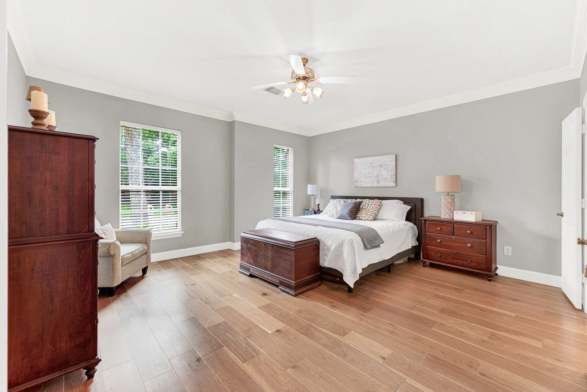 Generous crown molding frames the soaring ceiling, enhancing the open and airy layout. Imagine waking up to soft morning light filtering through the tall windows.