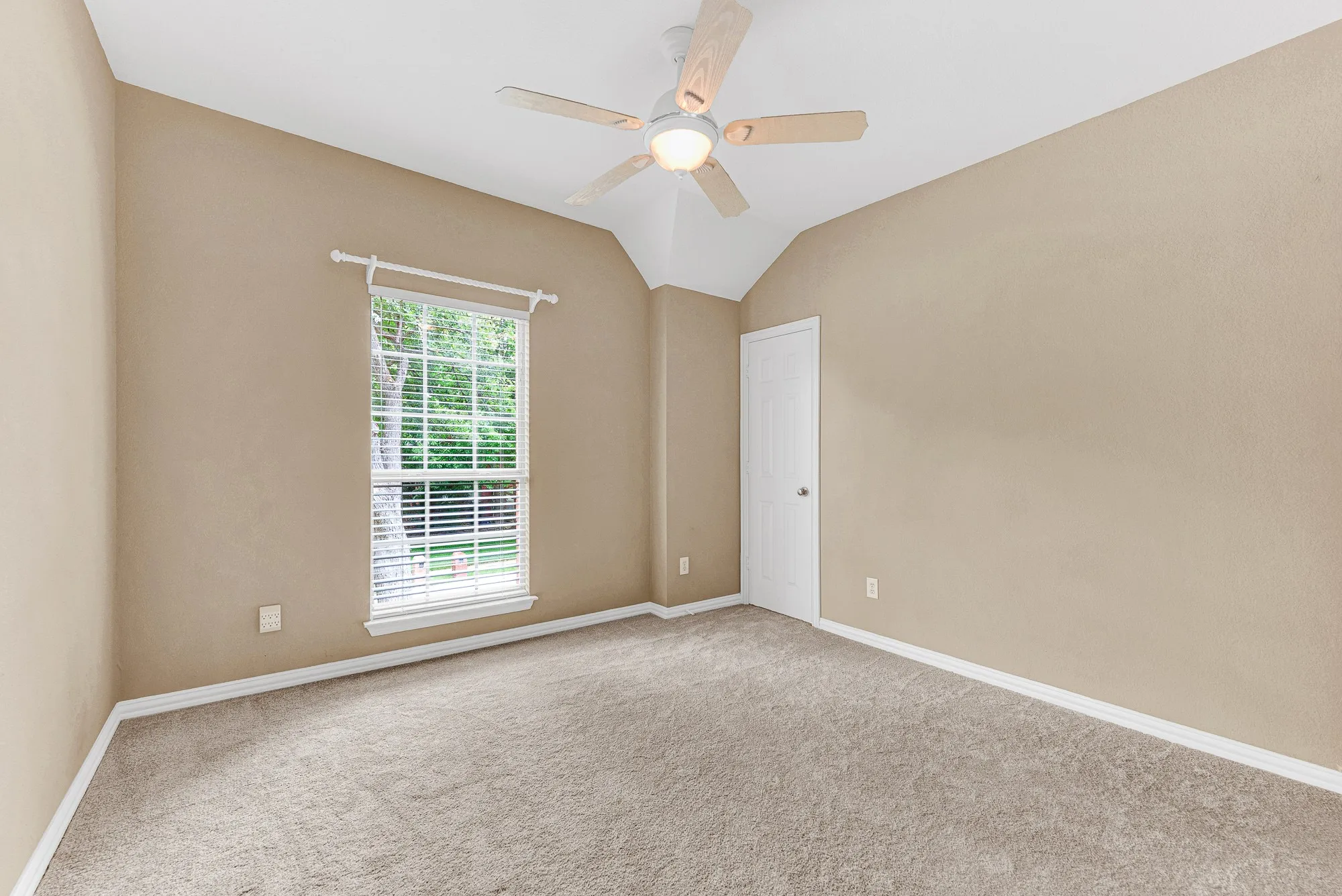 A high ceiling draws the eye upward, giving this cozy secondary bedroom an unexpectedly spacious and airy feel. You can look forward to peaceful afternoons watching the sunlight dance across the walls as the breeze stirs outside.