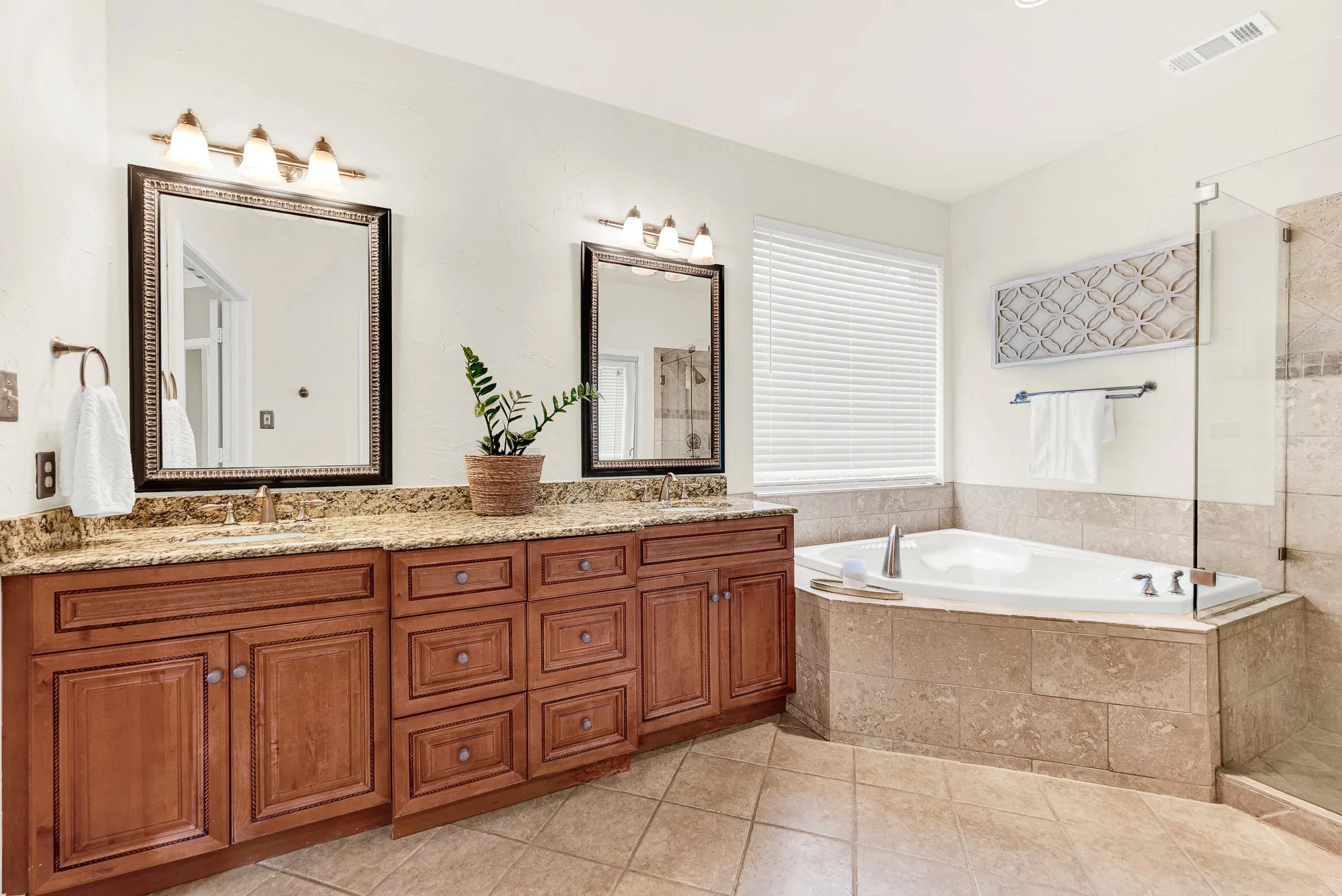 An oversized soaking tub serves as the room's central retreat, tucked beneath a wide window. Sink into a warm evening bath to wash away the day.