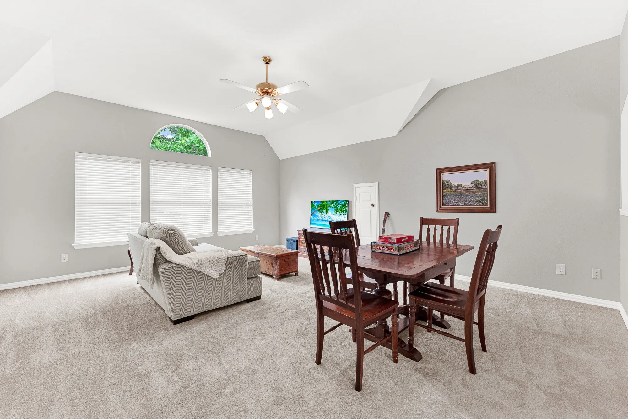 Dramatic vaulted ceiling angles draw the eye upward, amplifying the room's sense of openness. Imagine spending a rainy Saturday afternoon completely relaxed here while natural light fills the space through the arched window.