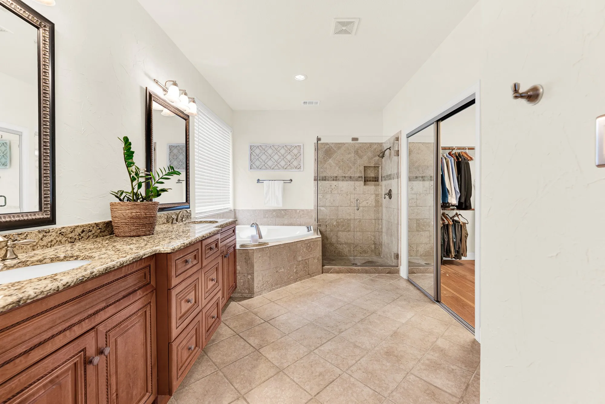 The expansive glass-enclosed shower brings a modern, airy feel to the tile-wrapped sanctuary. Start your day with a refreshing, sun-drenched morning routine.