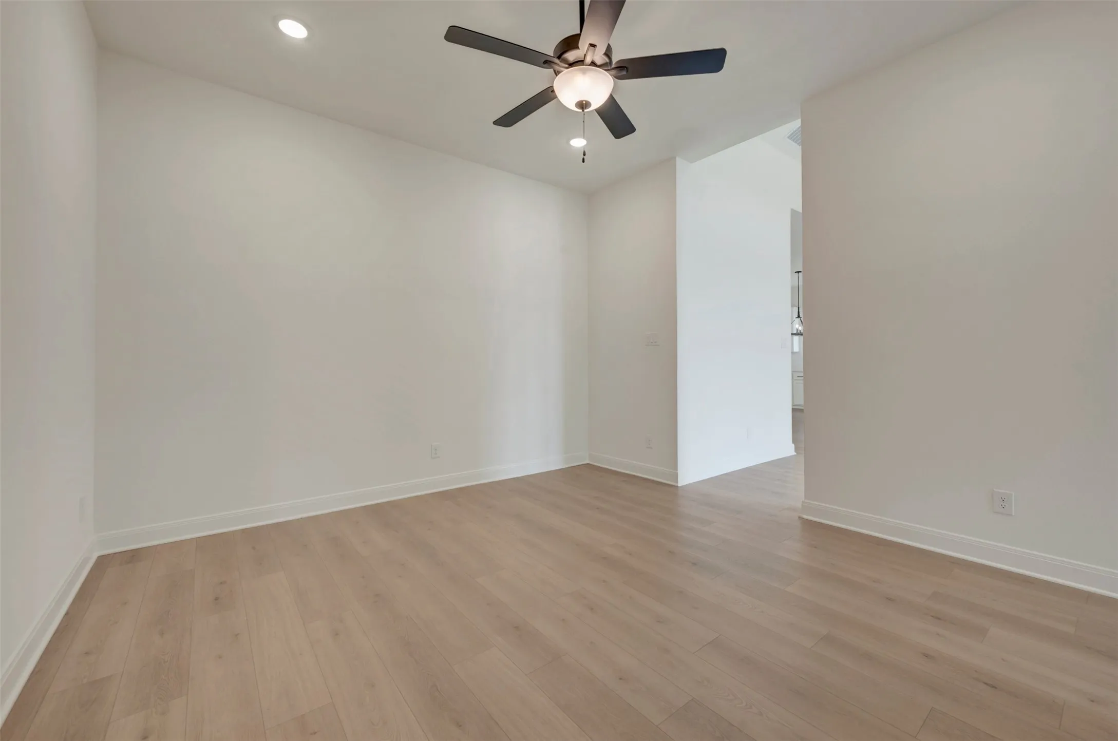 Wood-finish flooring, recessed lighting, ceiling fan with light fixture, and neutral wall tones