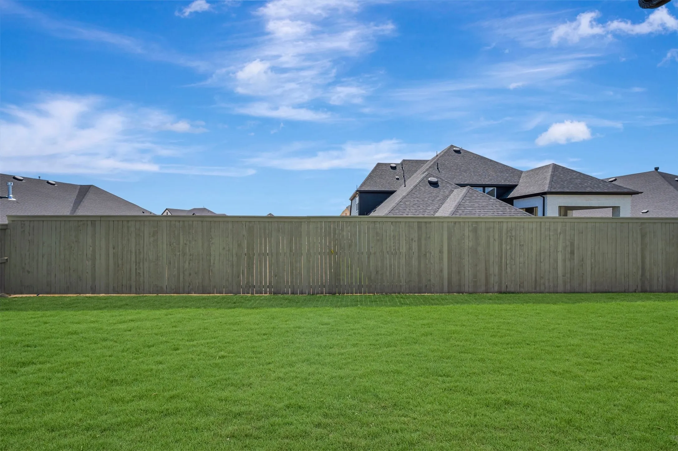 Expansive lawn with a wooden privacy fence