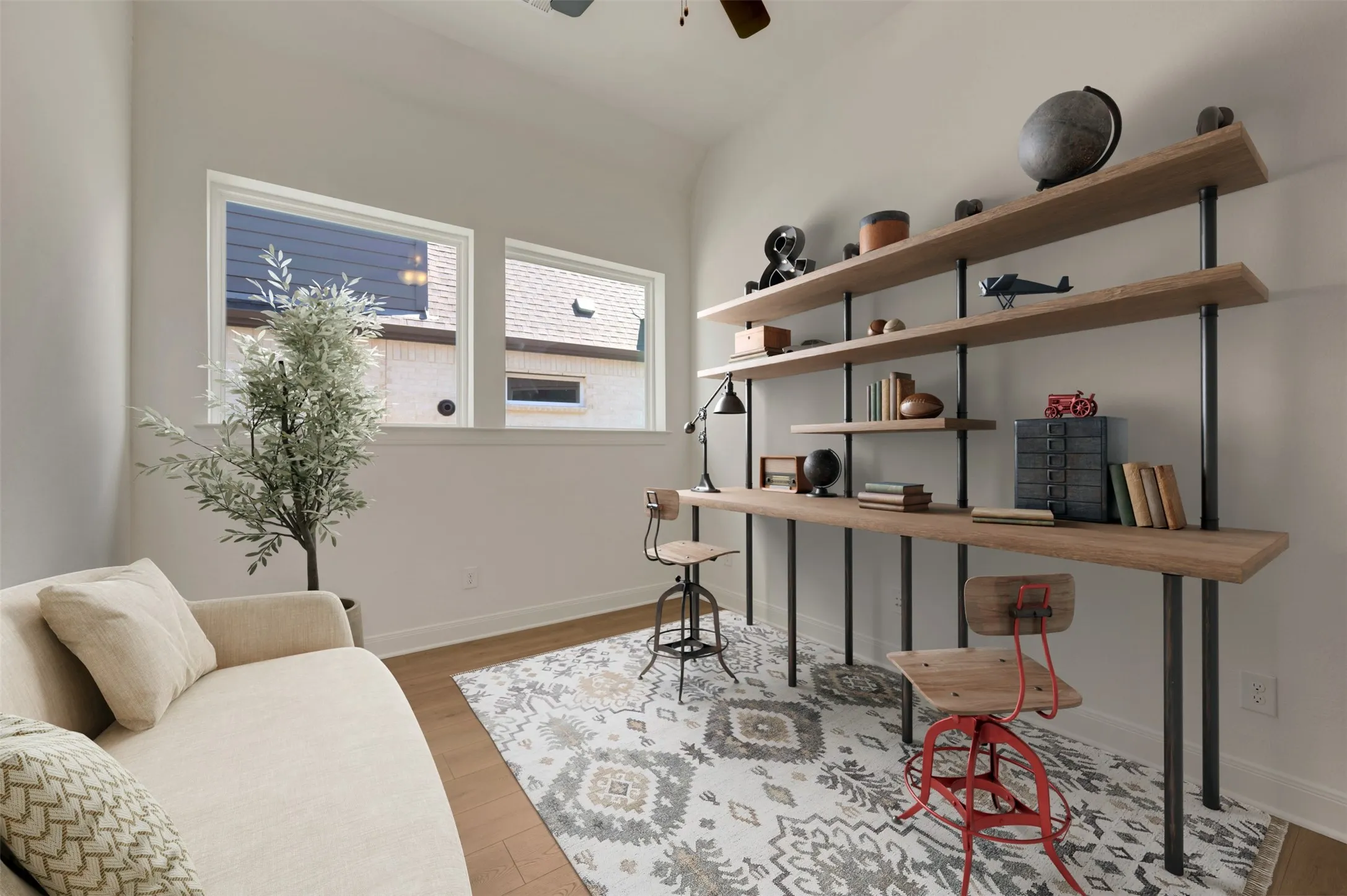 Angled ceiling, multiple windows, wood-finish flooring, built-in shelving, and a ceiling fan
