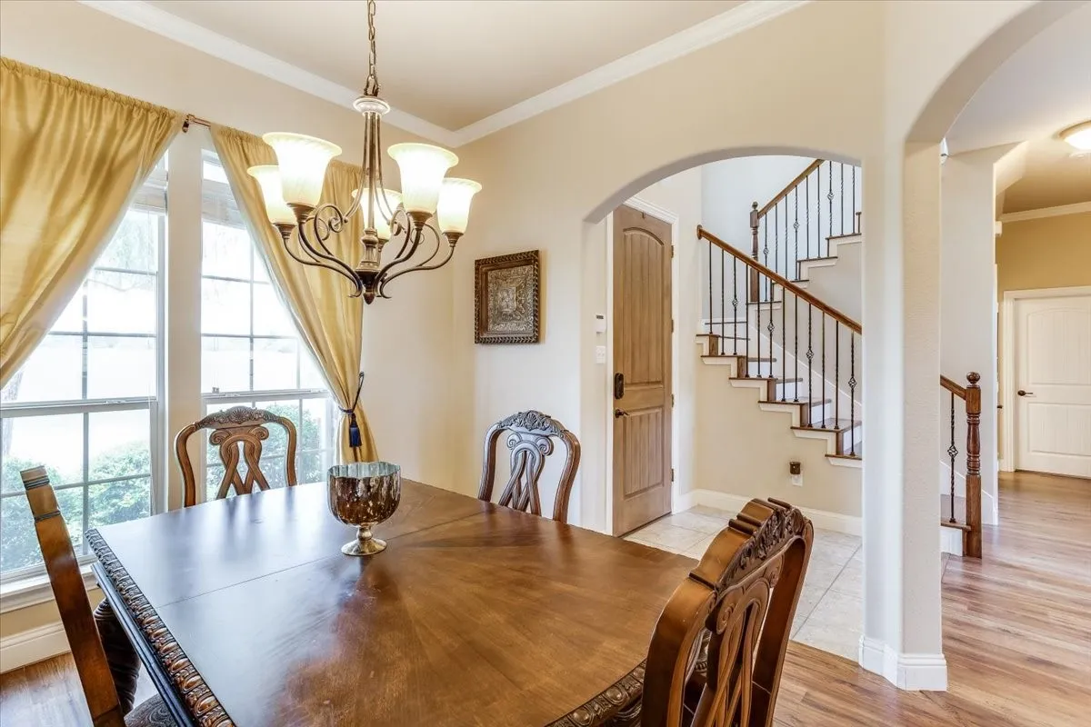 Formal dining area featuring a dark wood-finish dining table and a five-light chandelier