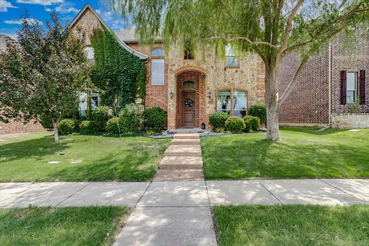 Brick and stone-clad exterior with mature landscaping