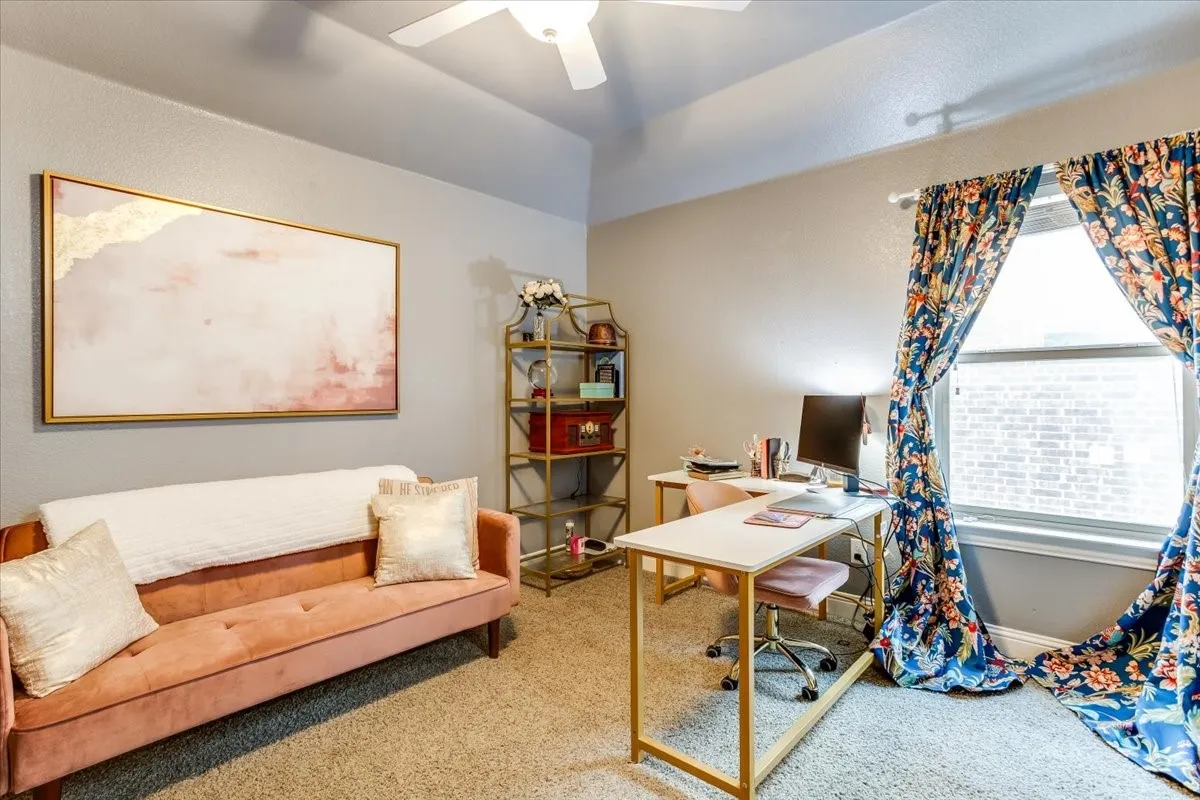 Carpeted room with a vaulted ceiling and a ceiling fan