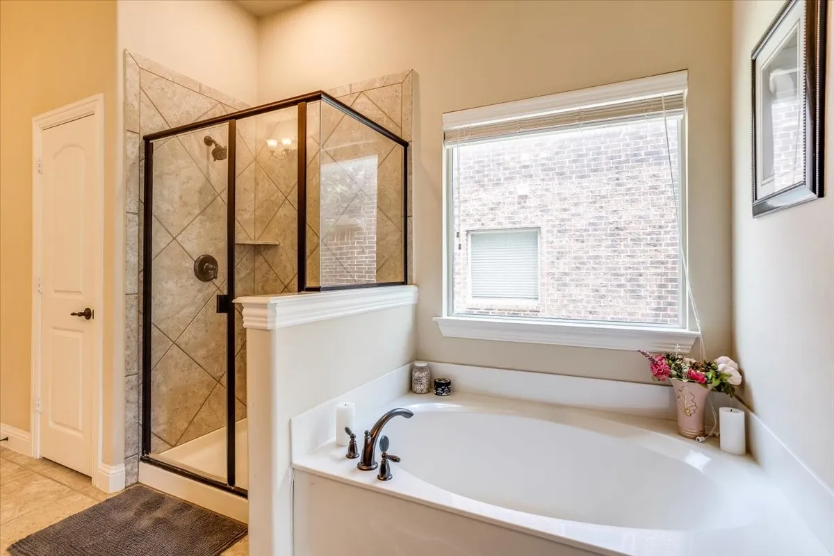 Built-in soaking tub with dark bronze fixtures and a surrounding white countertop