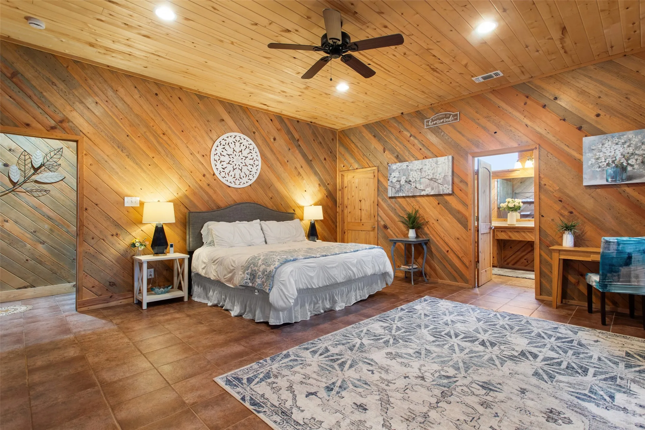 Vaulted wood-paneled ceilings and walls complement the wood-finish flooring in this spacious room