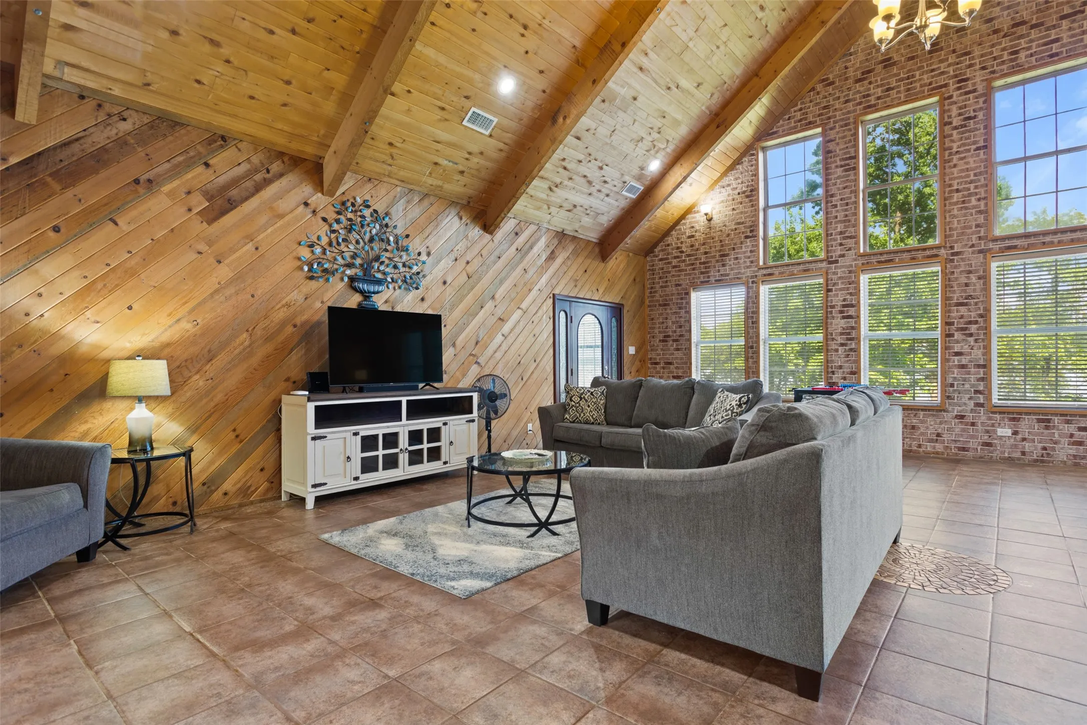 Living area featuring vaulted wood ceilings with exposed beams and recessed lighting