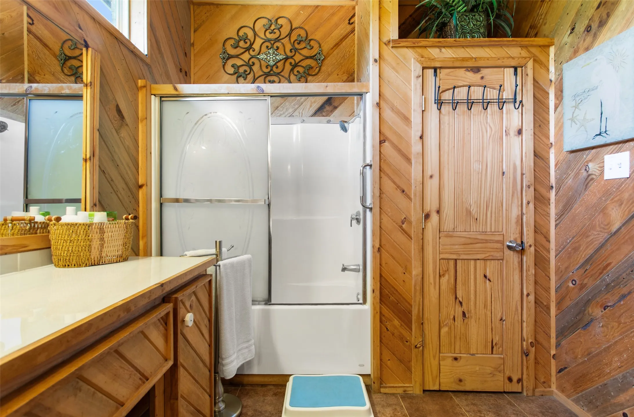 Bathroom featuring wood-paneled walls and a built-in vanity with a light-colored countertop