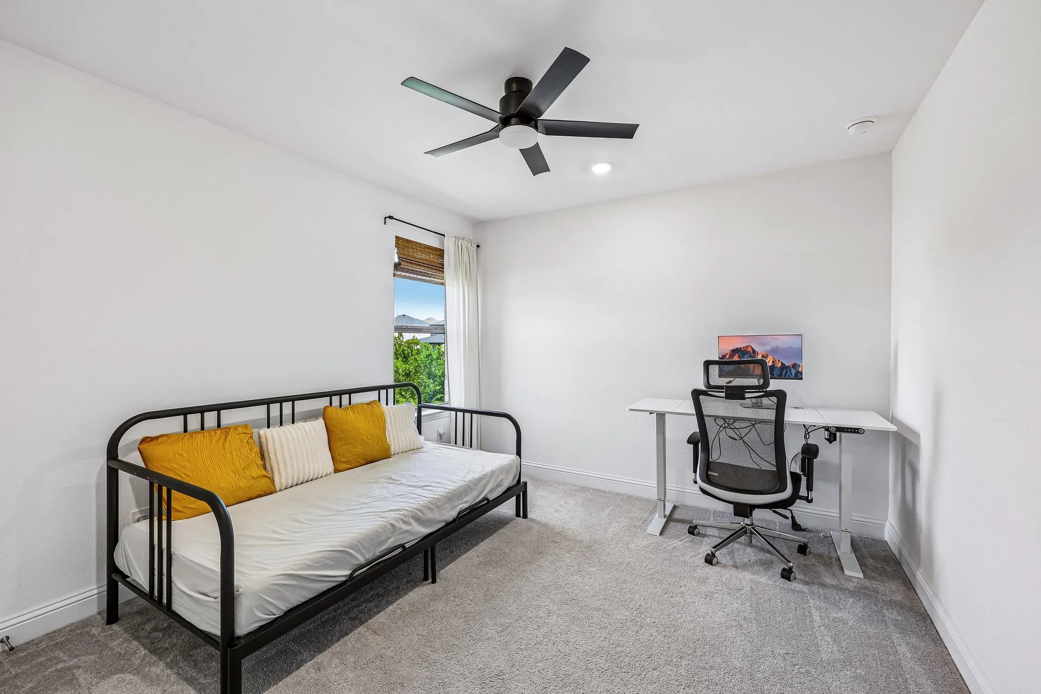 Bright room featuring a window with woven wood blinds, recessed lighting, a ceiling fan, and carpeted flooring