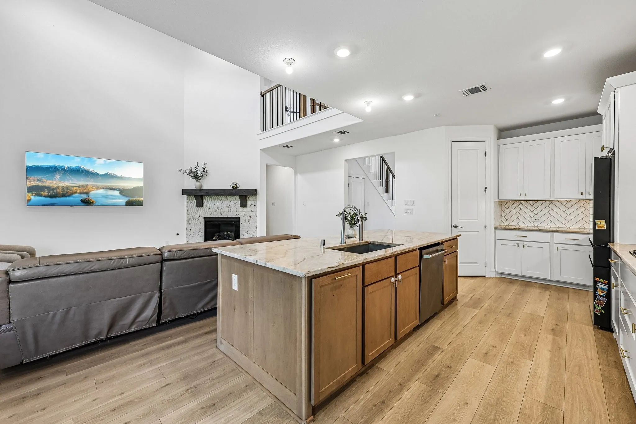 Open-concept living space featuring a central island with a granite-look countertop and integrated sink