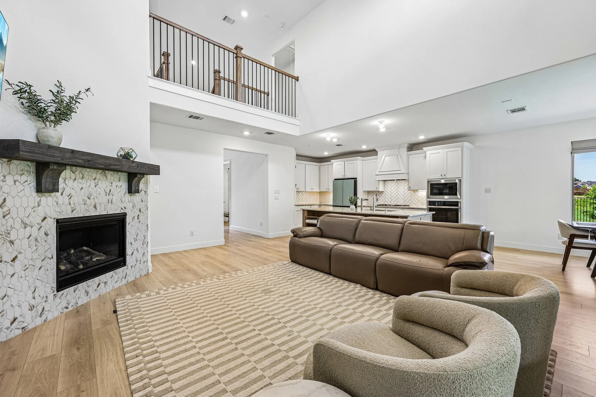Open-concept living area featuring high ceilings and wood-finish flooring