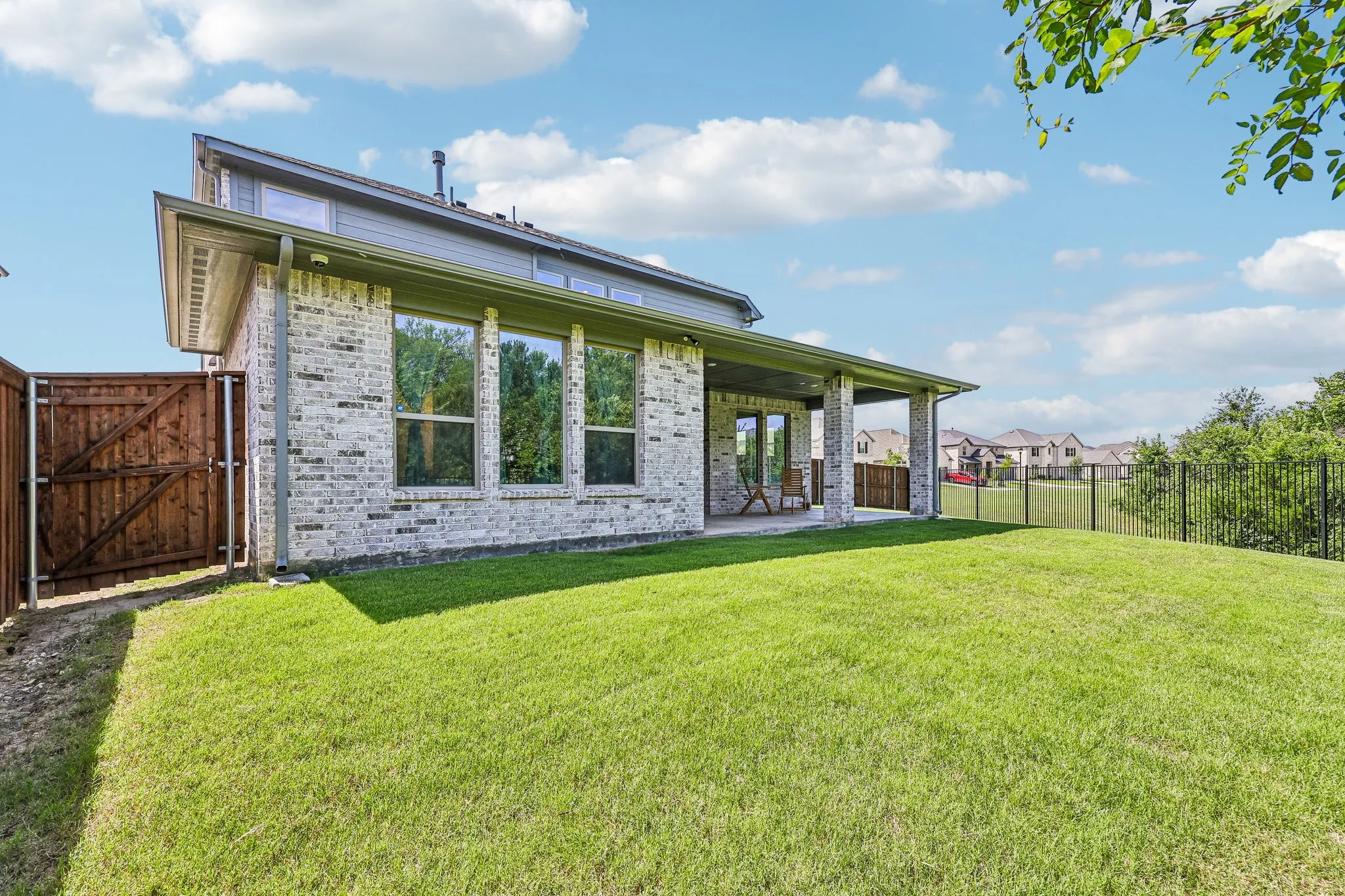 Expansive backyard featuring a manicured lawn, a covered patio, and a privacy fence