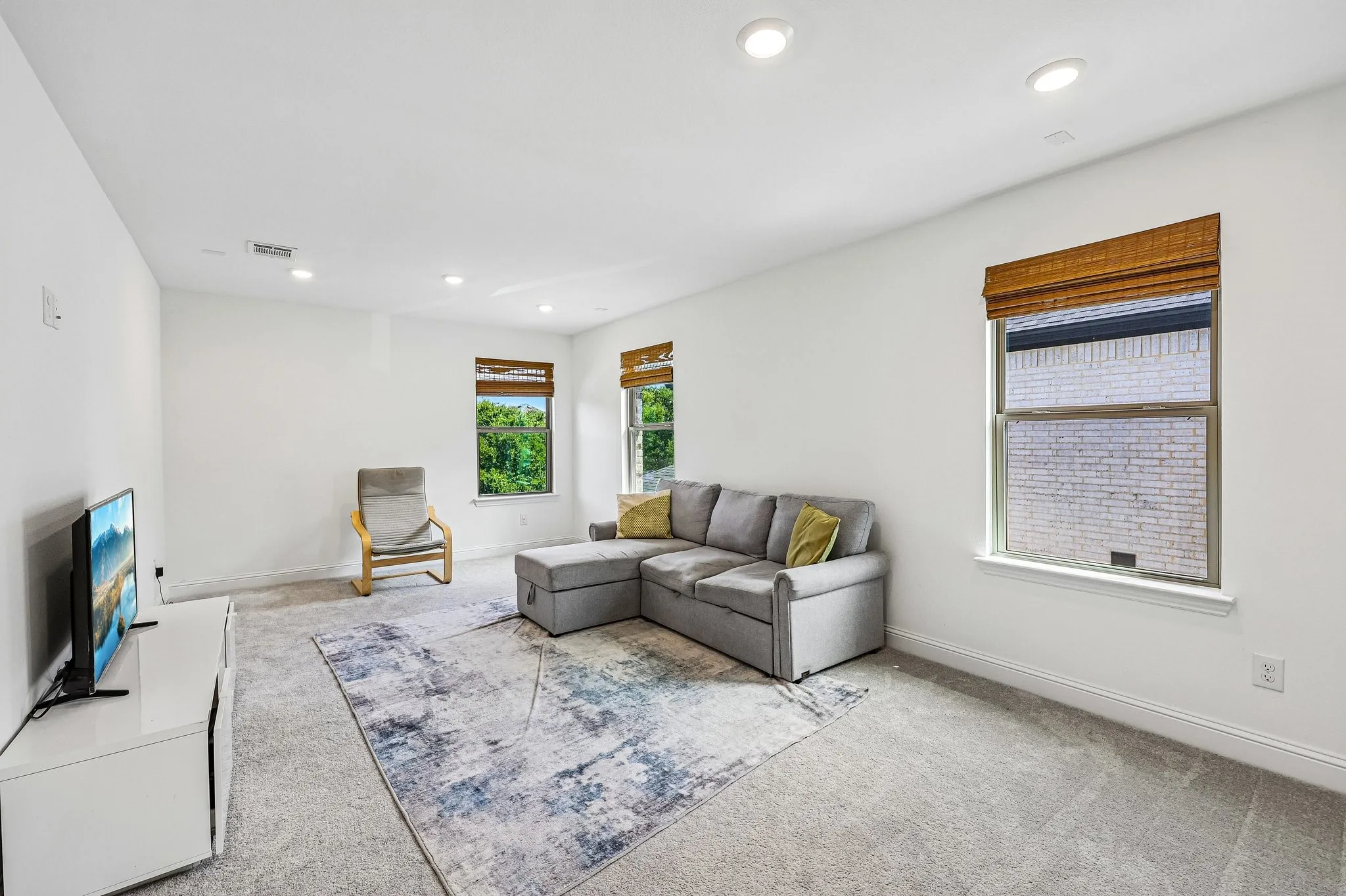 Carpeted room with white walls and recessed lighting