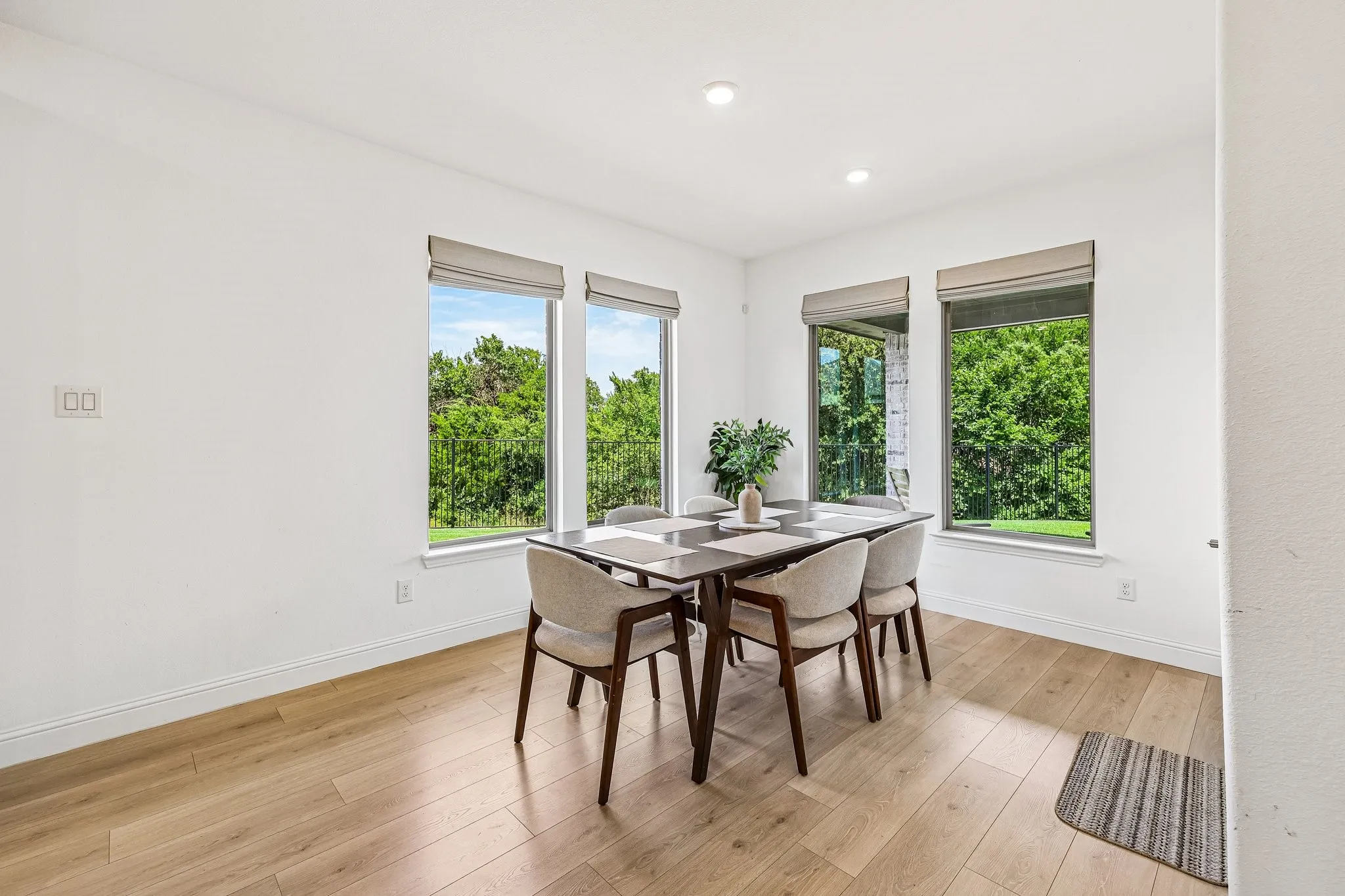Dining area featuring three large windows, recessed lighting, white baseboards, and wood-finish flooring