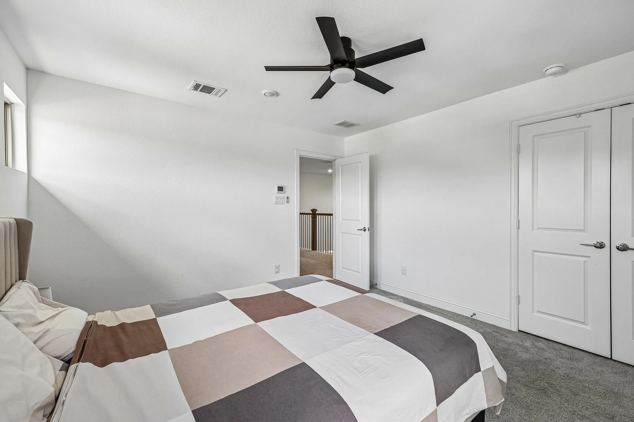 Bedroom featuring gray carpeting and clean white walls
