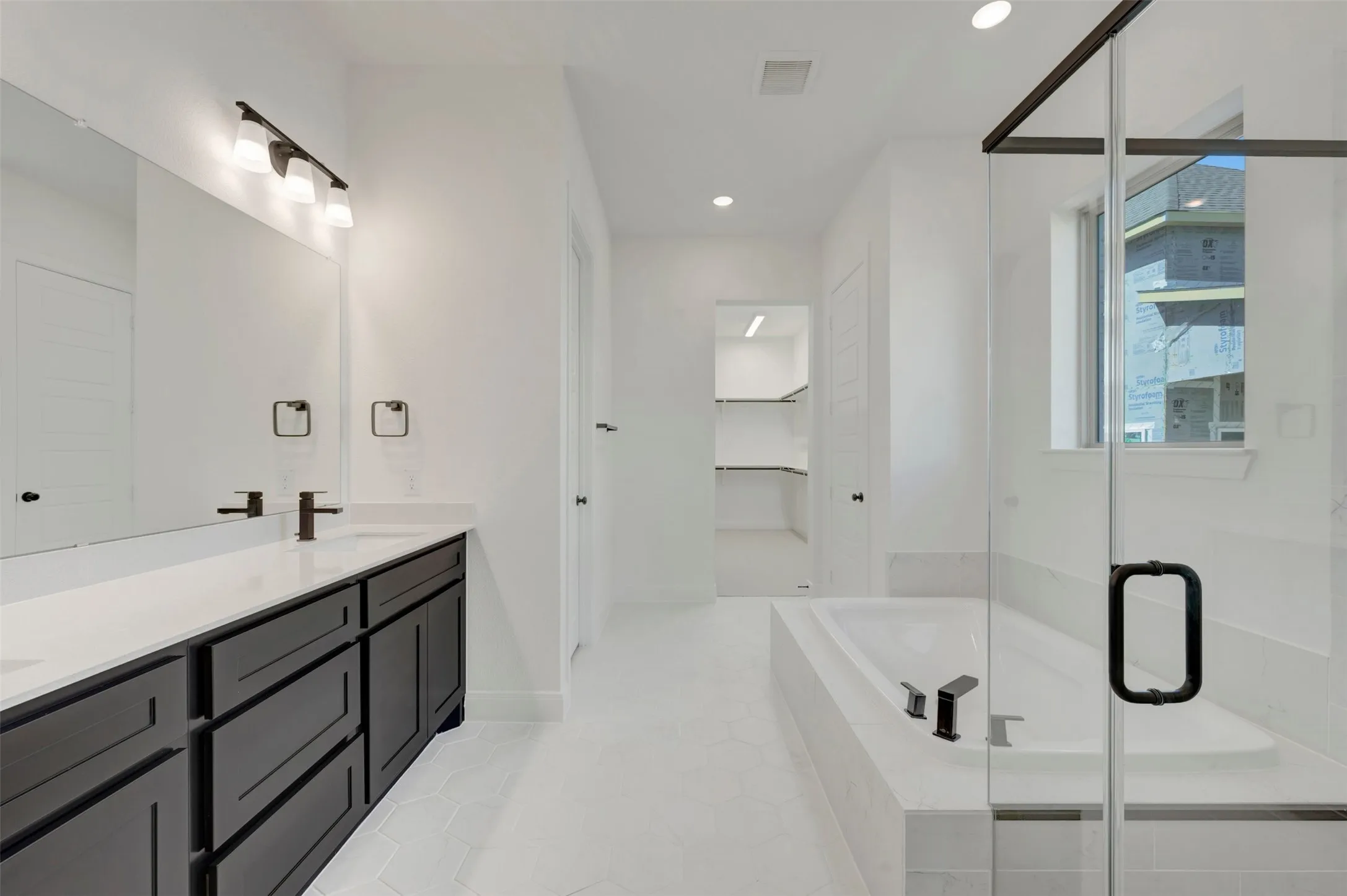 Dual vanity with dark wood-finish cabinetry and white countertops