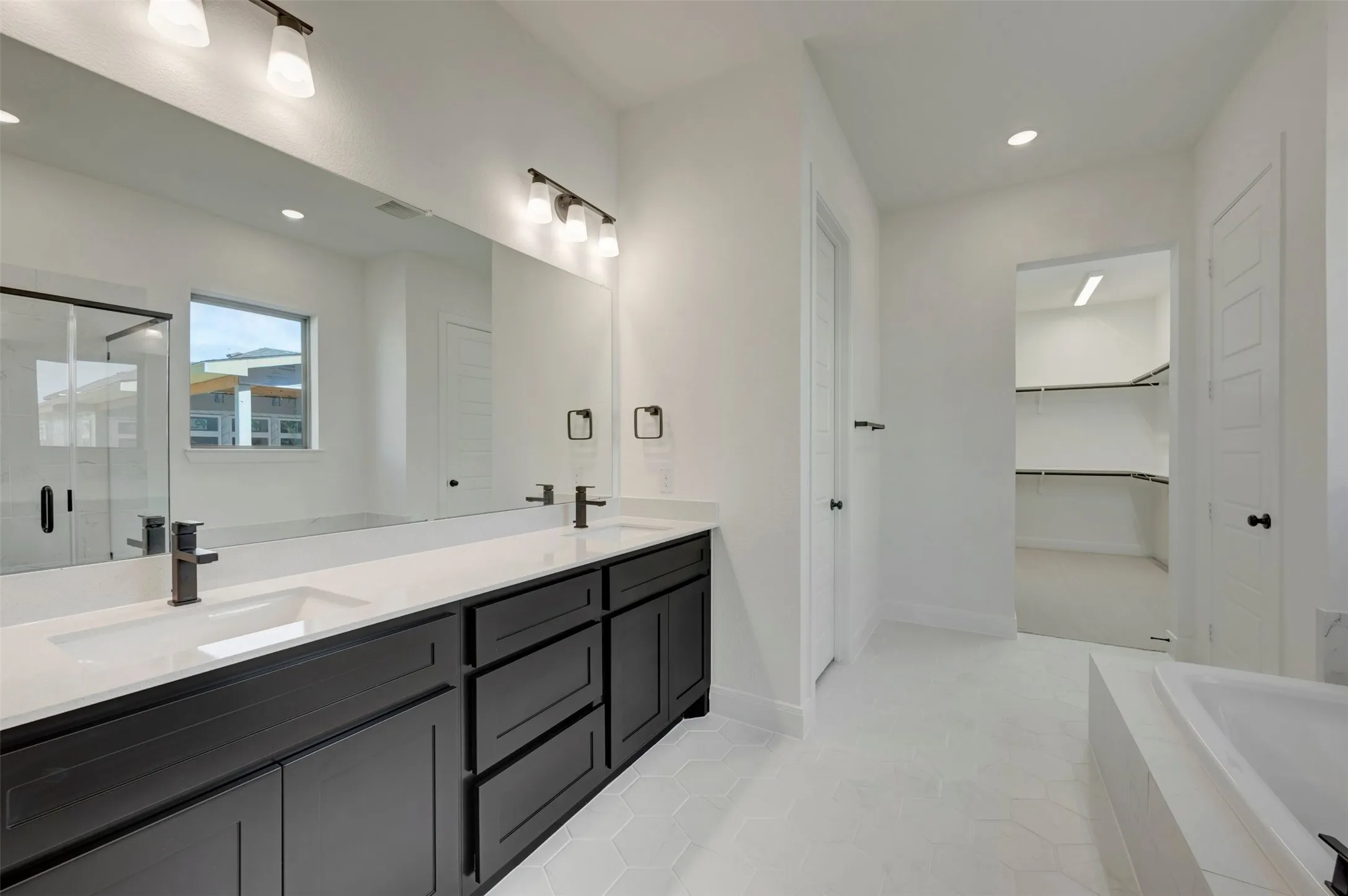 Dual vanity with black cabinetry and white countertops