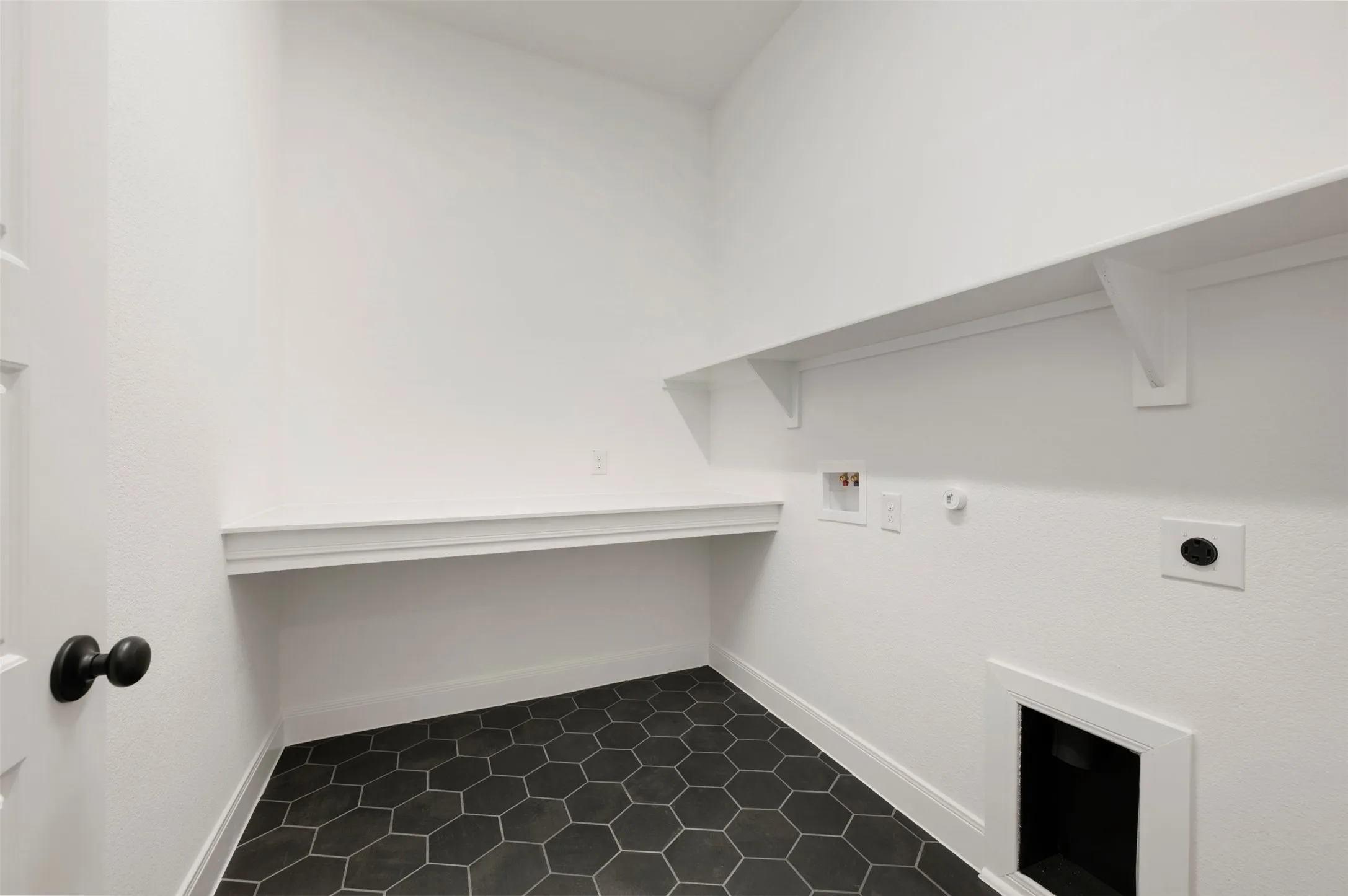 Hexagonal floor tiling, a built-in countertop, and an upper storage shelf