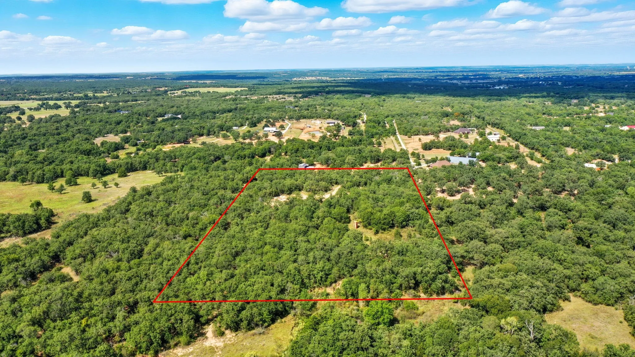 Aerial view of property's location with a heavily wooded area and property boundaries highlighted