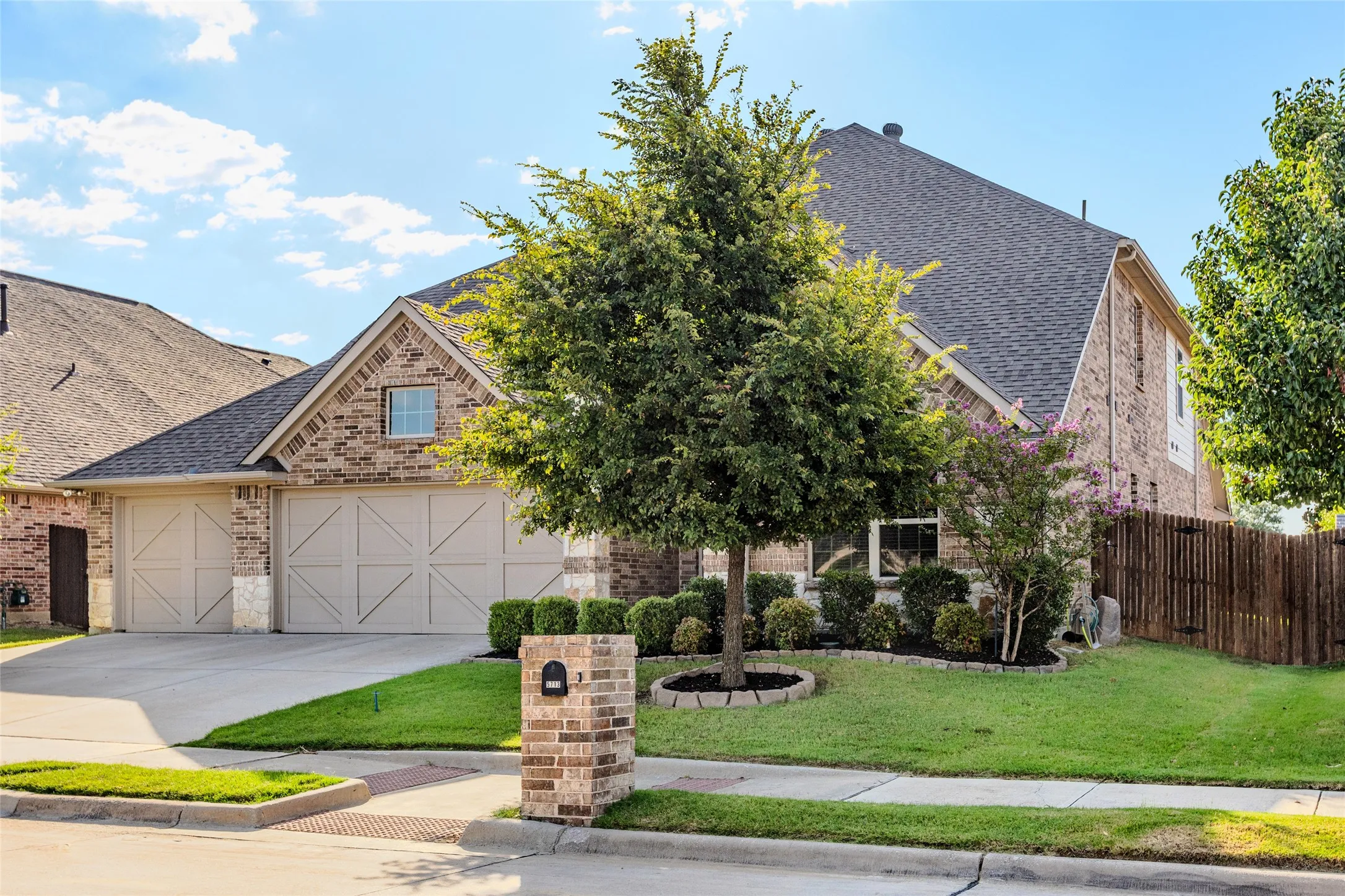 Brick and stone facade residence featuring a two-car garage with decorative doors