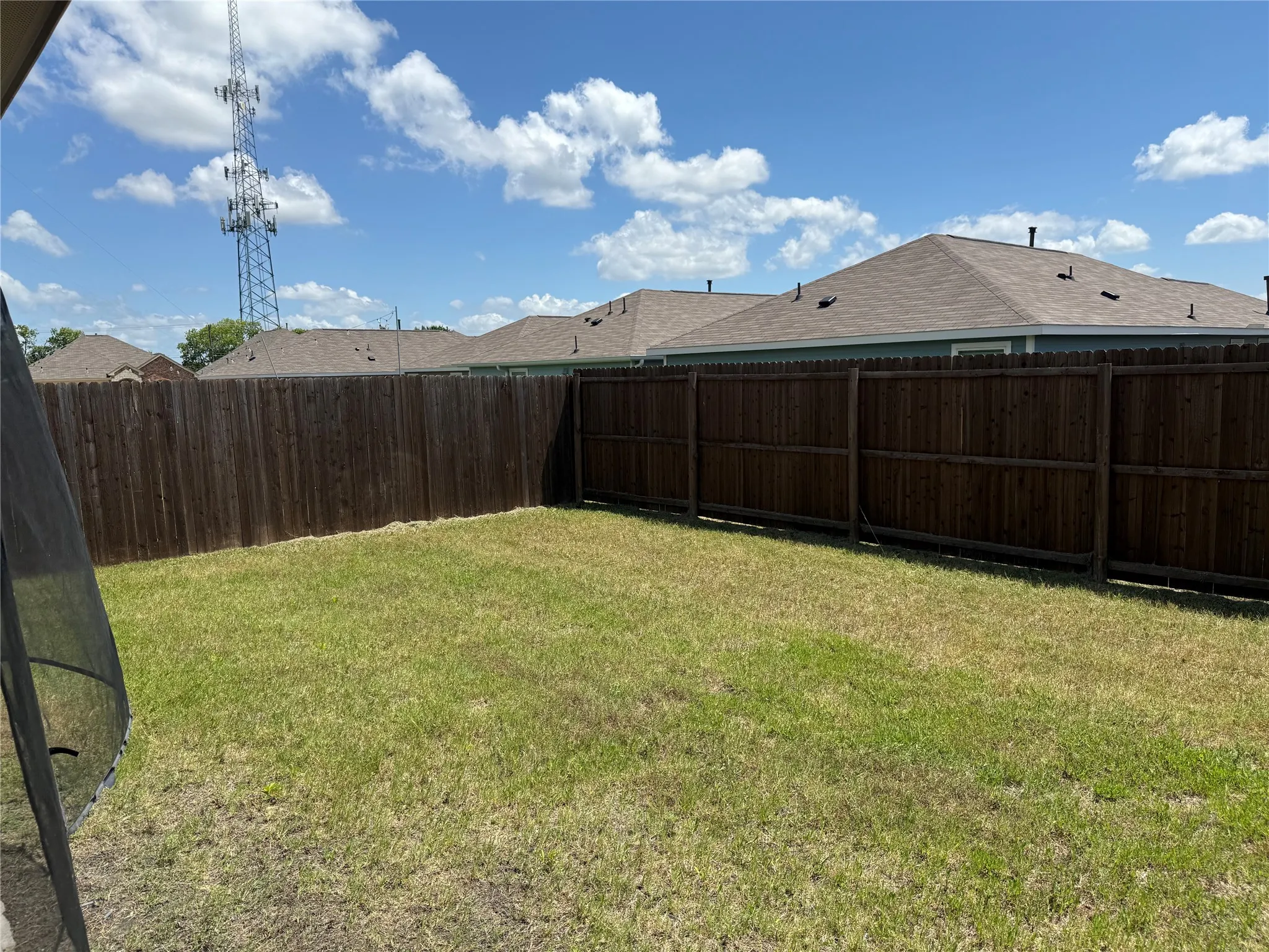 Expansive backyard featuring a privacy fence and a verdant lawn