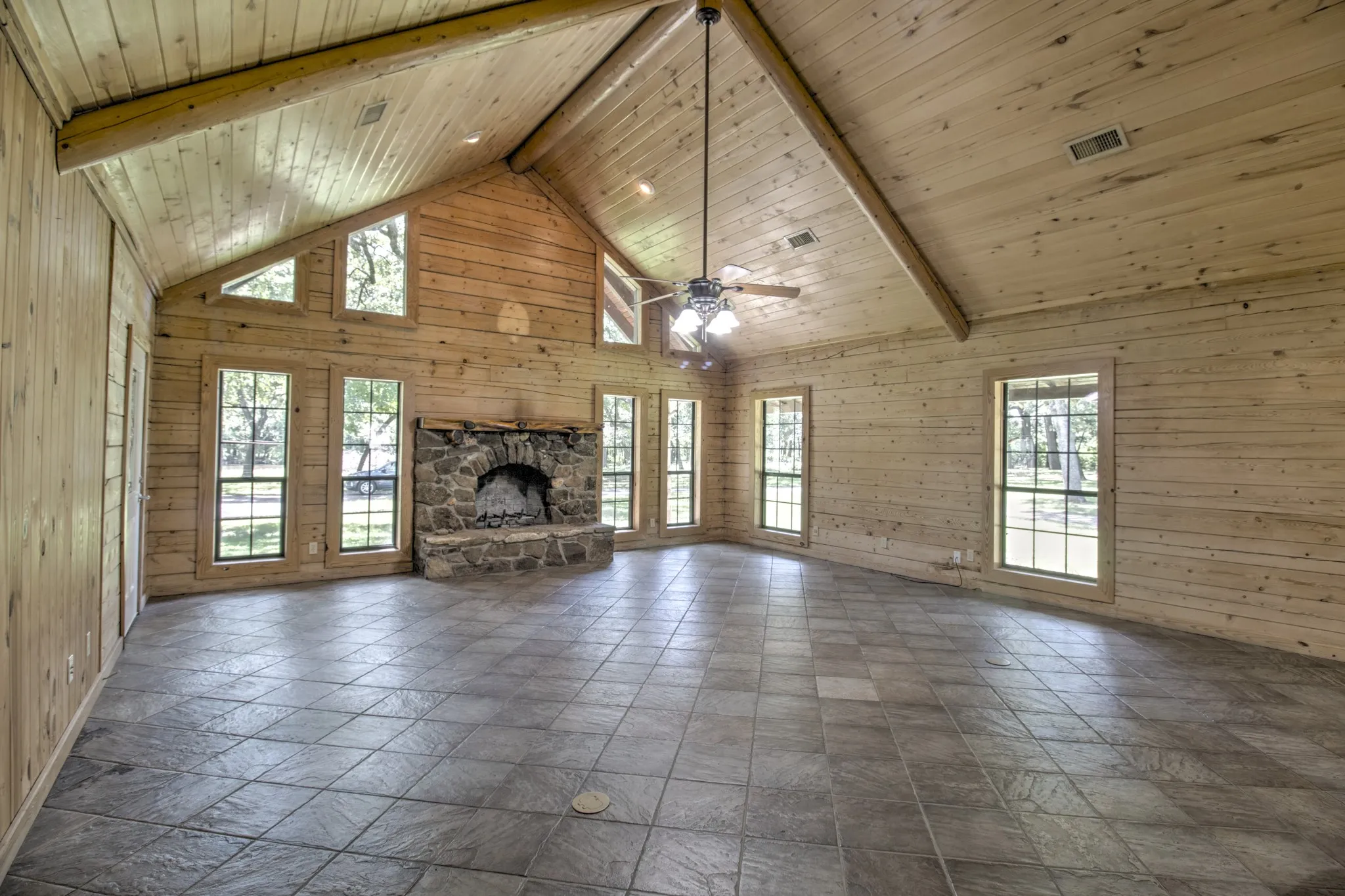 Soaring Cathedral ceilings ,custom-built stone fireplace with a thick log mantel stands as the room’s focal point!