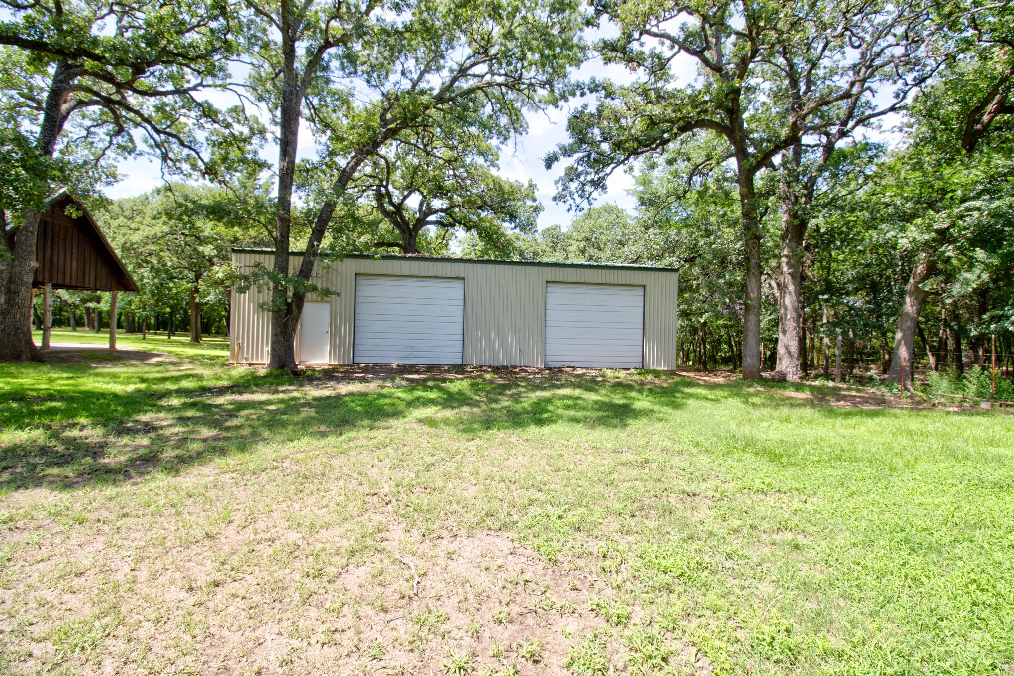 A large, detached shop provides ample space for a workshop, vehicle storage, or hobby farm equipment.