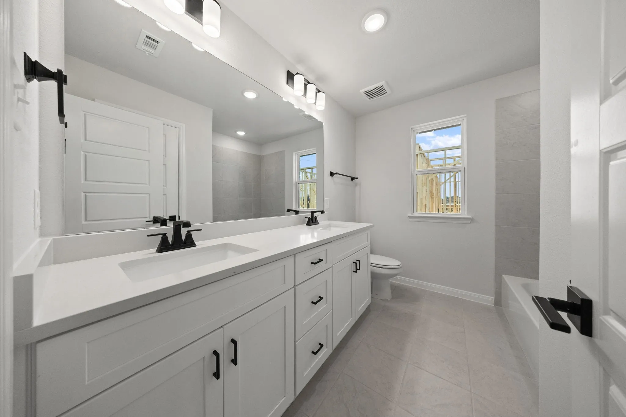 Guests will enjoy their own vanity space in this thoughtfully designed guest bath.