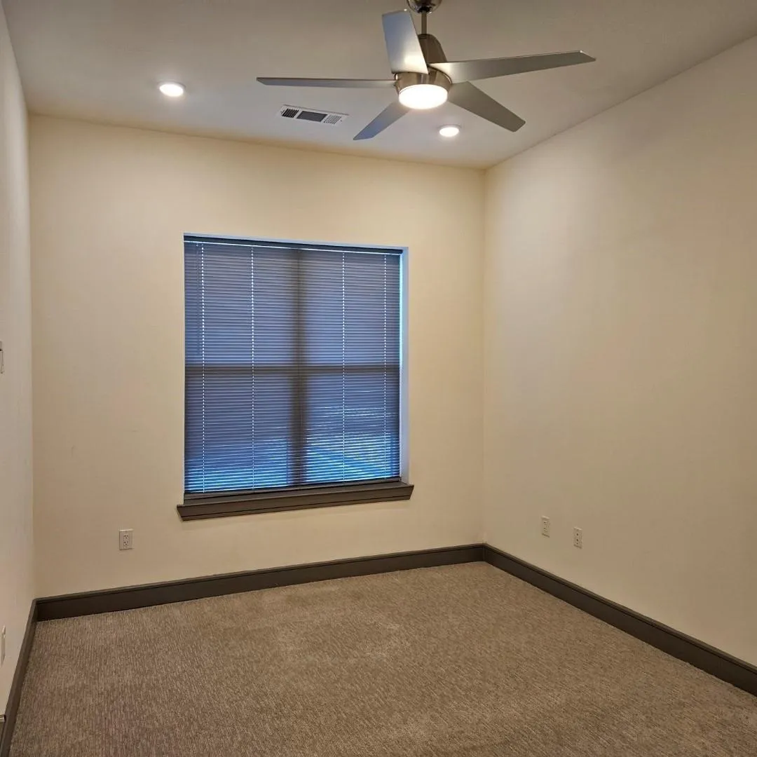 Carpeted room featuring a window with horizontal blinds, a ceiling fan with integrated lighting, recessed lighting, and dark-toned baseboards
