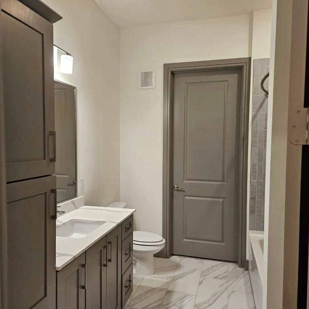 Modern bathroom featuring a single vanity with stone-finish countertop, wood-finish cabinetry, and an integrated rectangular sink