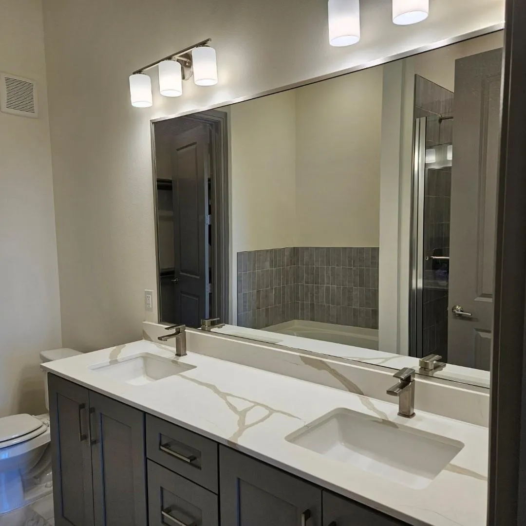 Dual vanity with a white countertop featuring prominent veining, integrated rectangular sinks, and brushed nickel faucets