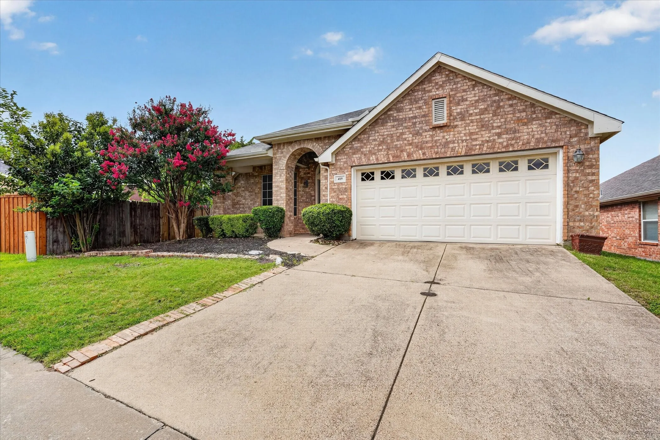 Brick exterior residence featuring an arched entry