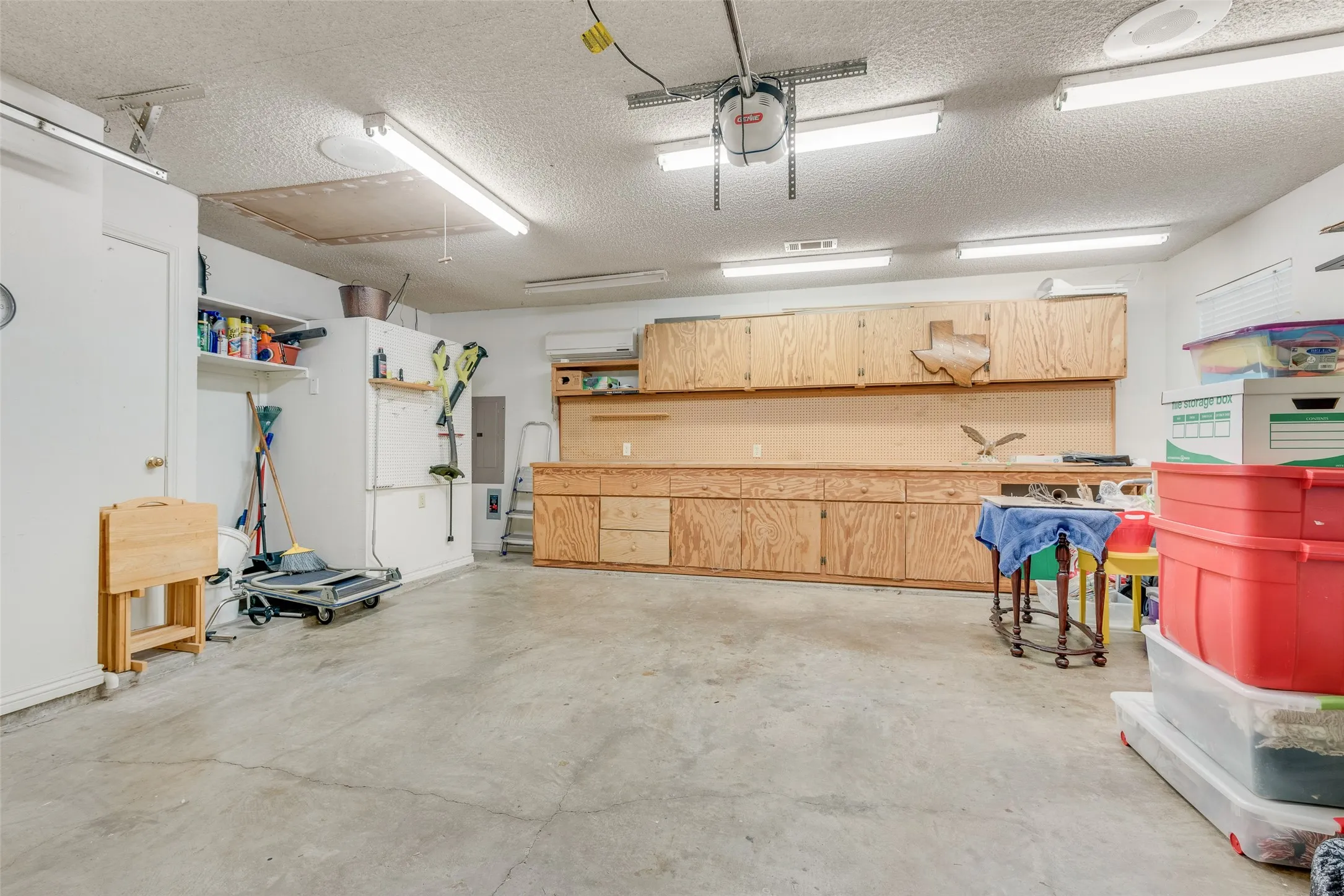 2 car garage with built in work bench with a secondary attic access