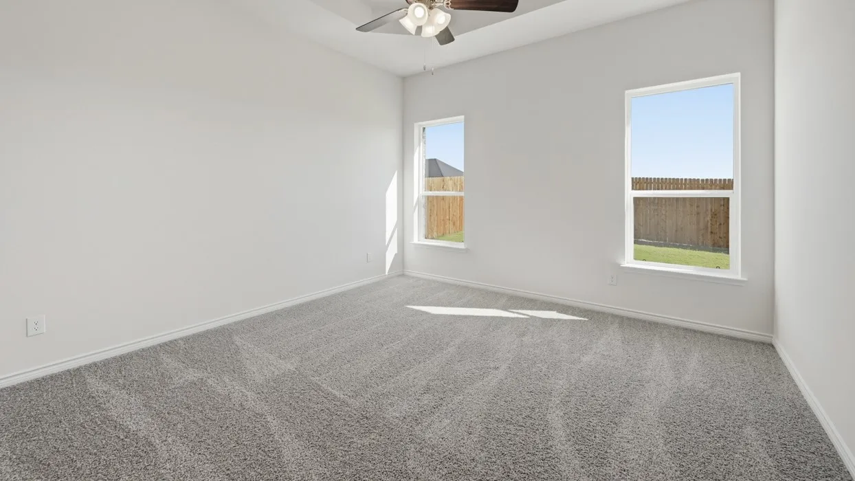 Vaulted ceiling with a ceiling fan, two windows, wall-to-wall carpeting, and white baseboards