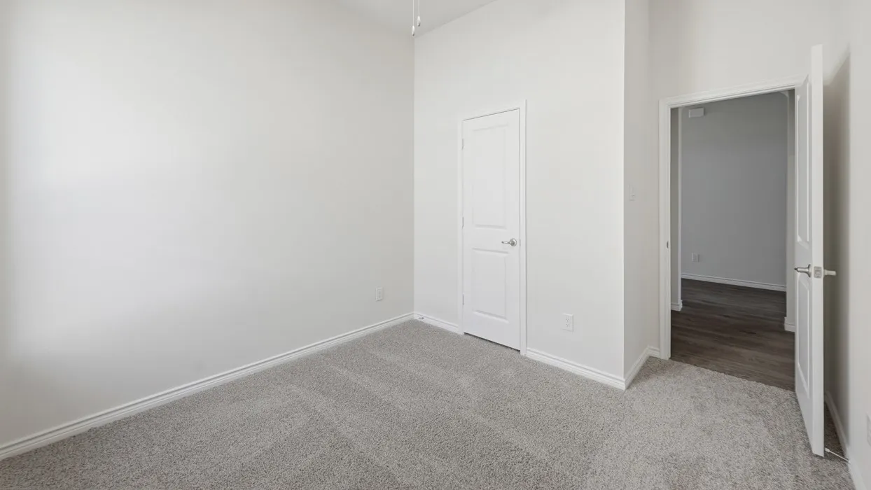 Spacious interior room with light grey carpeting