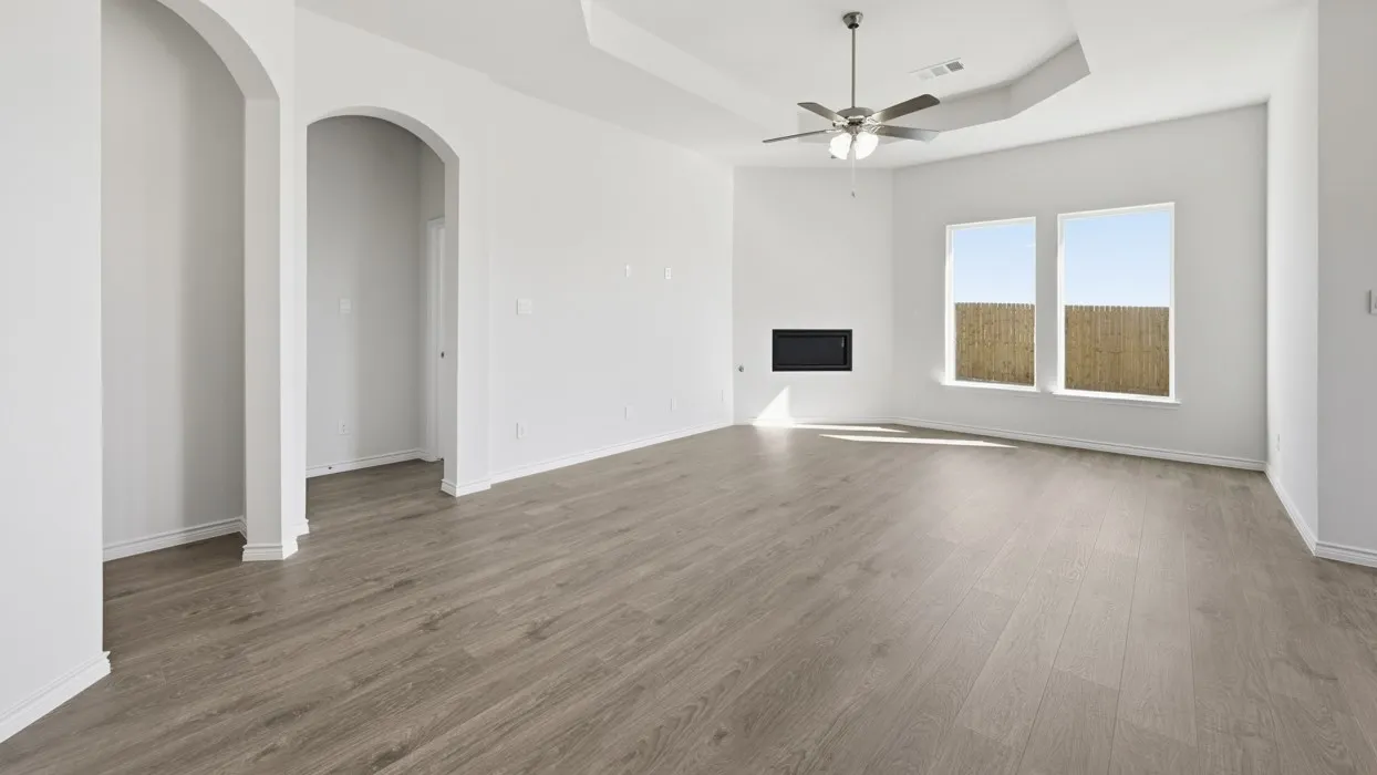Spacious interior featuring wood-finish flooring, a contemporary fireplace, and two large windows