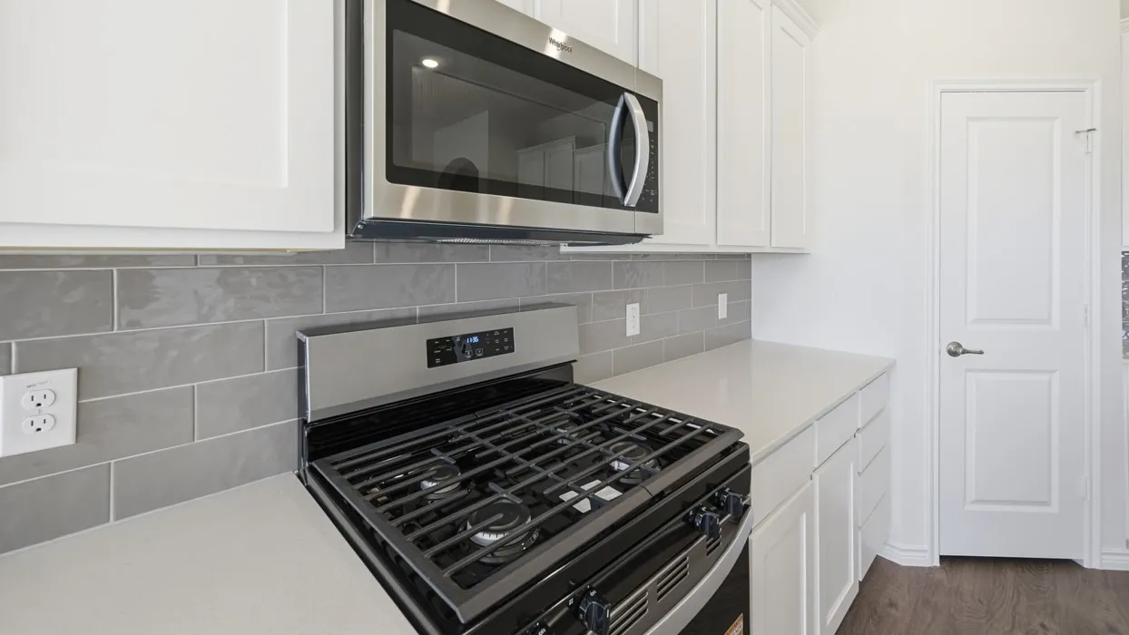 Stainless steel range with gas burners, complemented by an over-the-range microwave