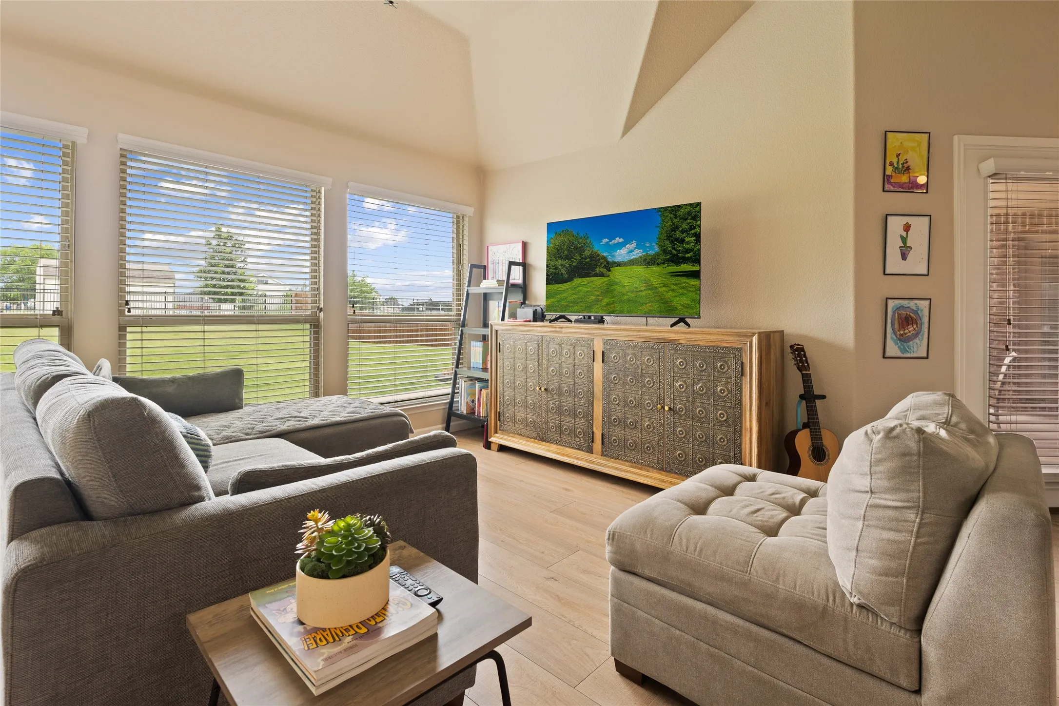 Living area featuring wood-finish flooring and a vaulted ceiling