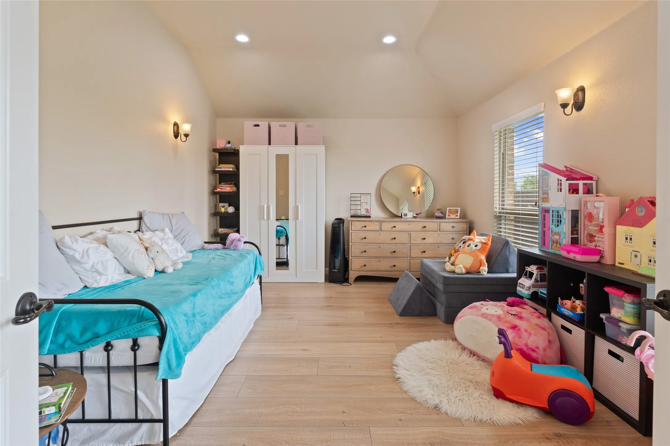 Spacious room featuring wood-finish flooring, a vaulted ceiling, and recessed lighting