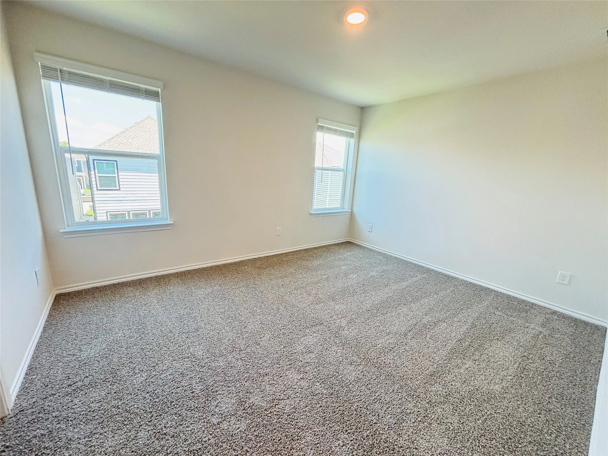 Spacious room featuring neutral carpeting and light-toned walls