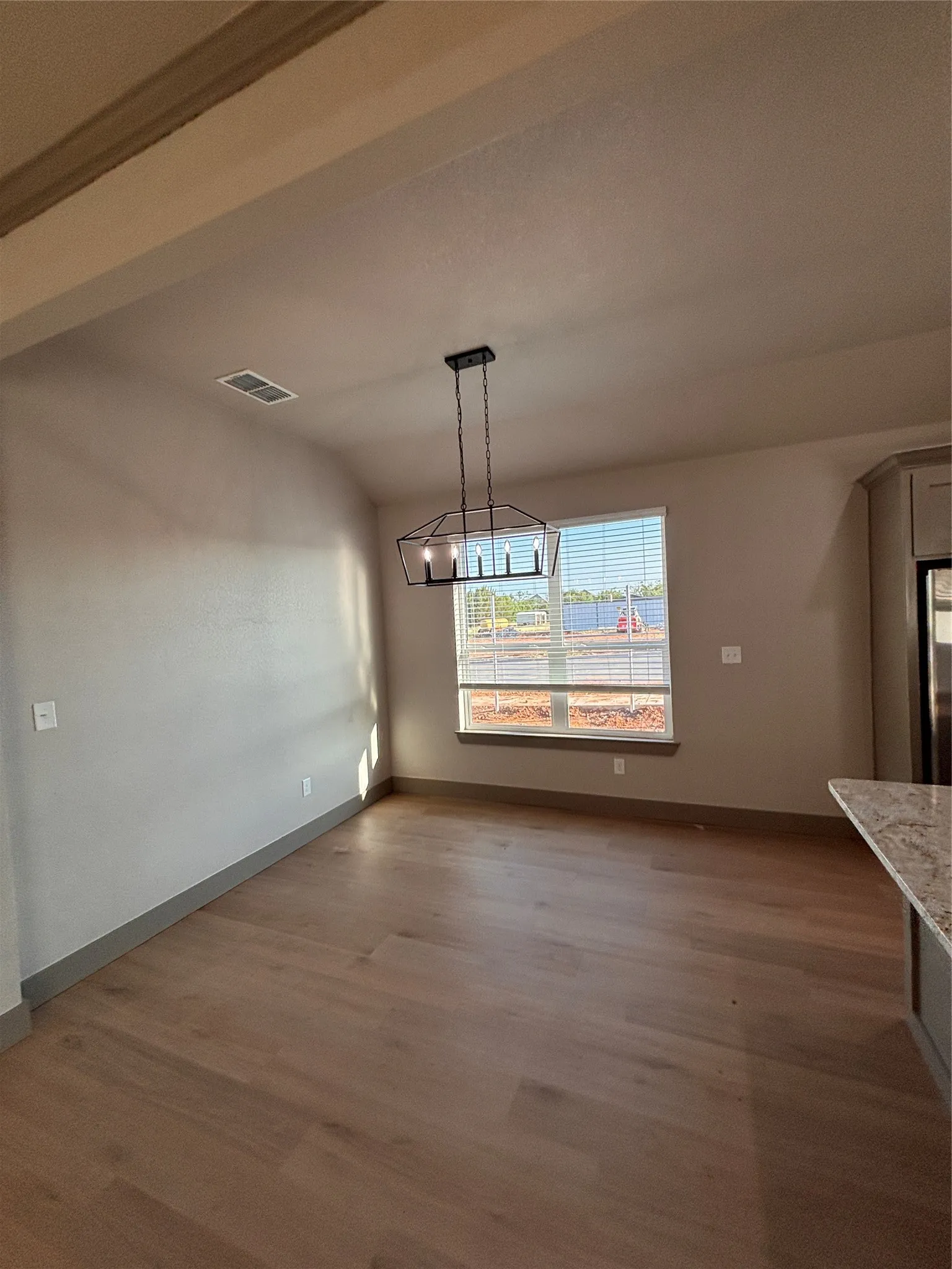 Spacious interior with neutral wall tones and wood-finish flooring
