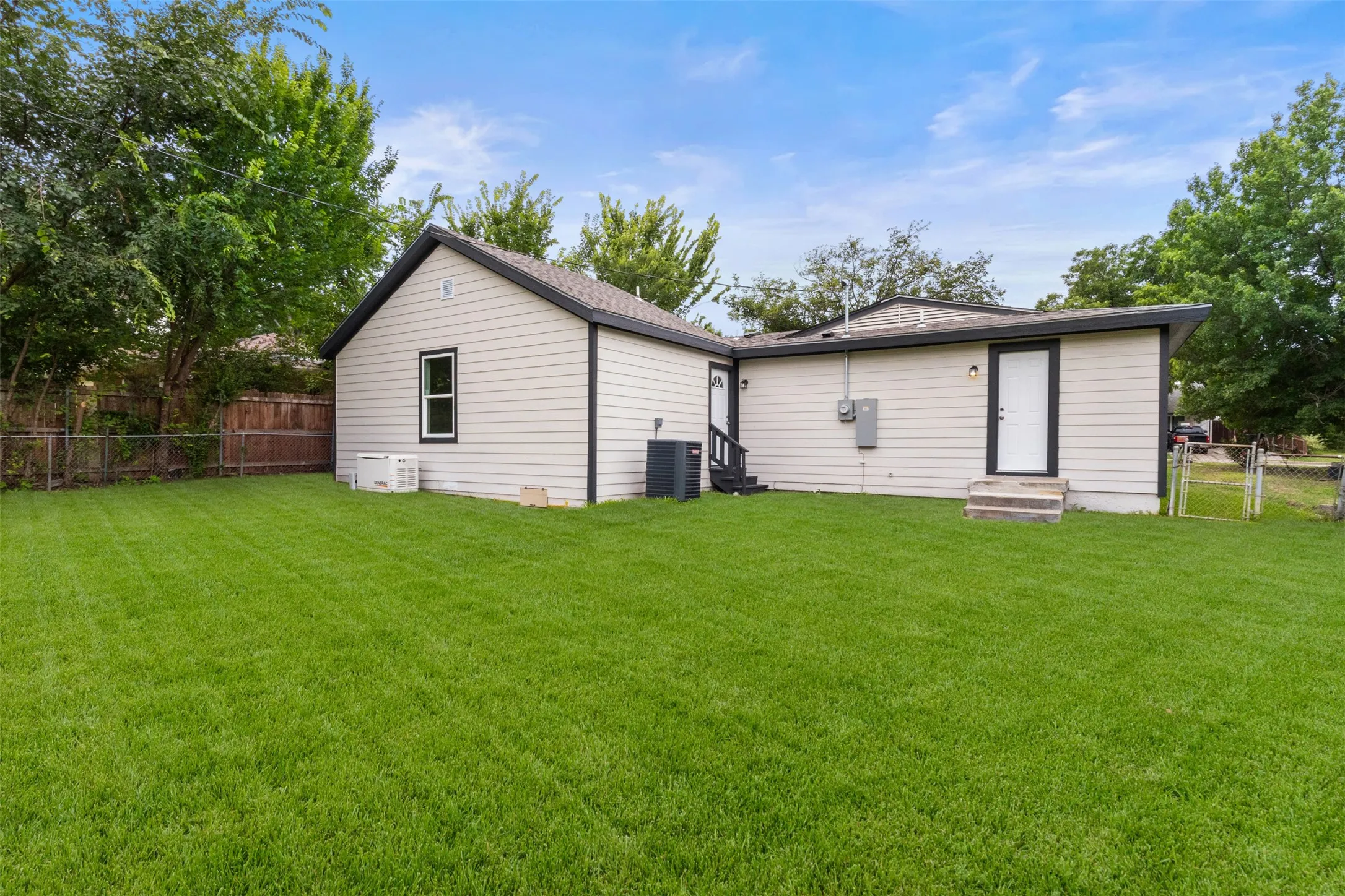 Expansive green lawn with a wood fence perimeter